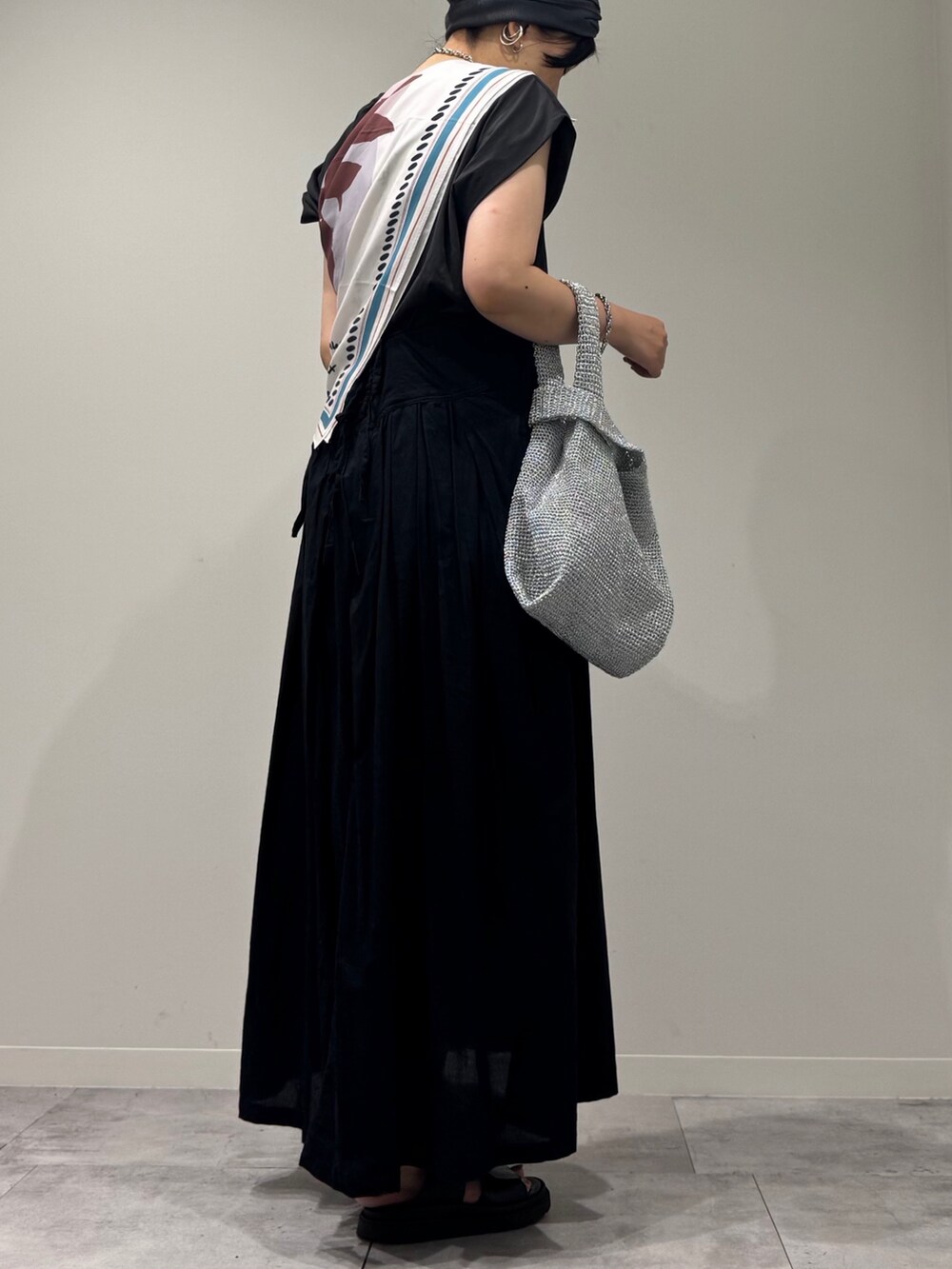 ブラック系のワンピース、シルバー系のかごバッグ、ブラック系のサンダルを着用したレディースの夏コーディネートの3枚目の写真