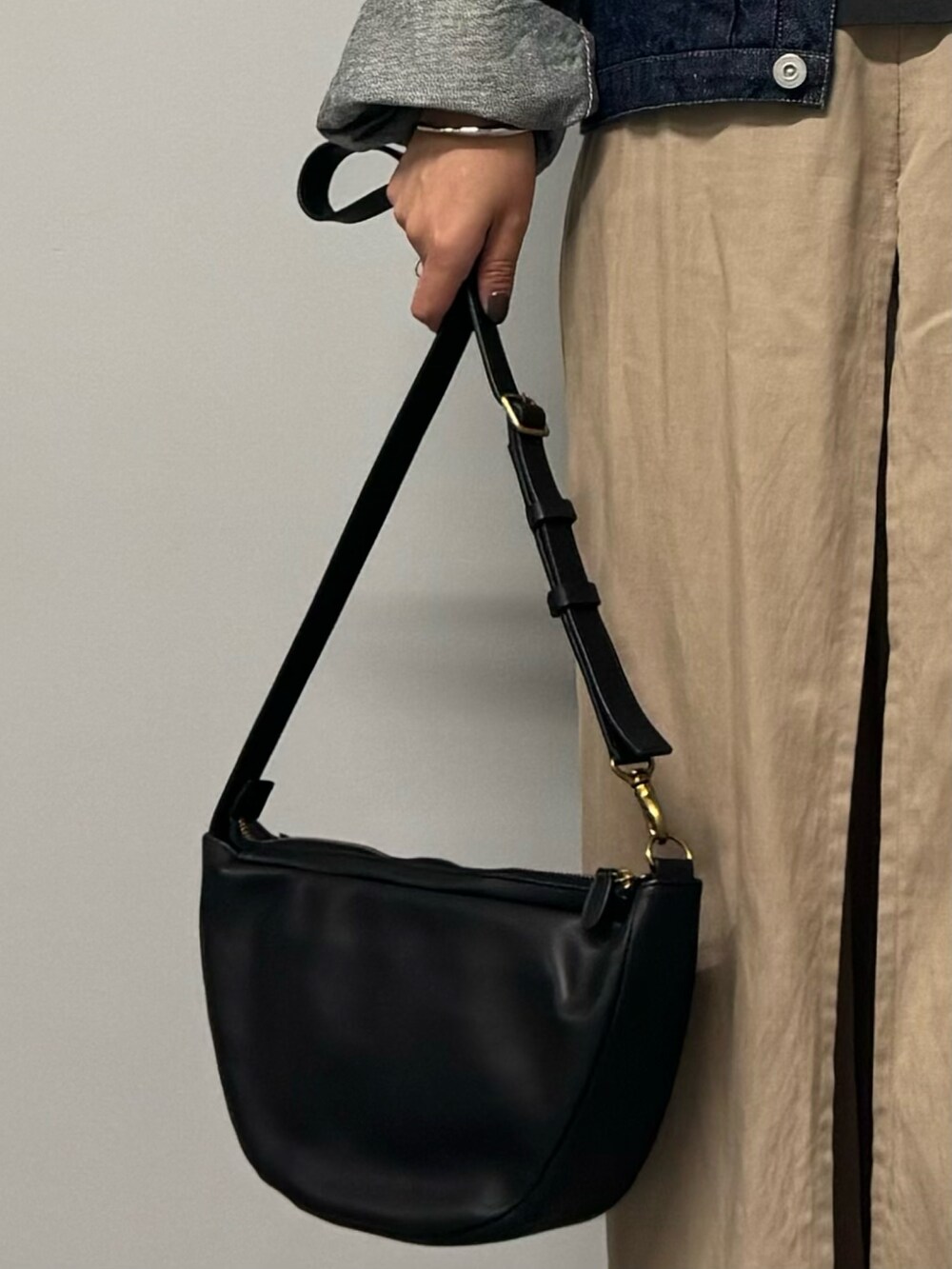 ブラック系のショルダーバッグ、グレー系のTシャツ/カットソー、ゴールド系のネックレスを着用したレディースの秋コーディネートの7枚目の写真