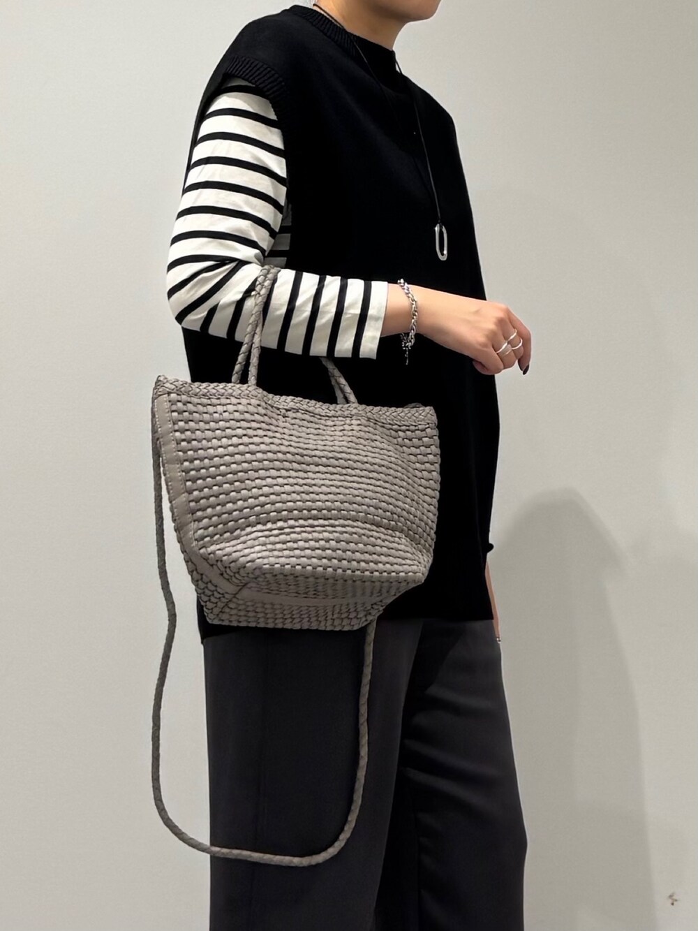 ベージュ系のトートバッグ、ブラック系のその他パンツ、ブラック系のTシャツ/カットソーを着用したレディースの秋コーディネートの9枚目の写真