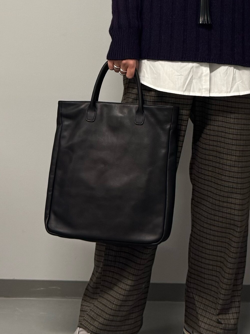 ブルー系のニット/セーター、ブラック系のトートバッグ、ブラウン系のその他パンツを着用したレディースの冬コーディネートの8枚目の写真