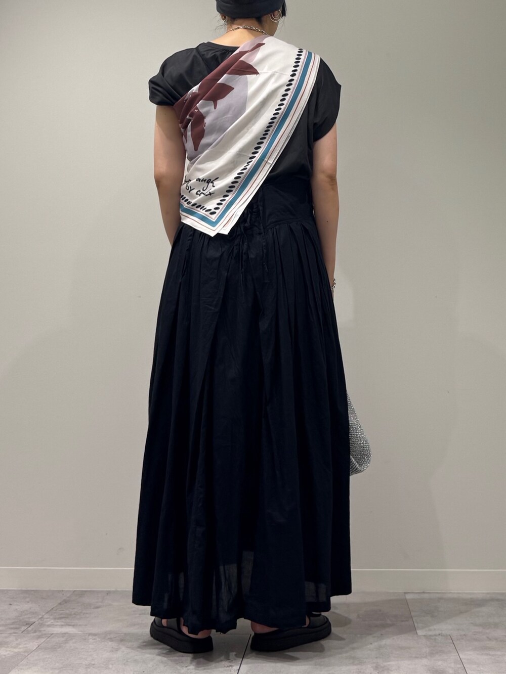 ブラック系のワンピース、シルバー系のかごバッグ、ブラック系のサンダルを着用したレディースの夏コーディネートの4枚目の写真