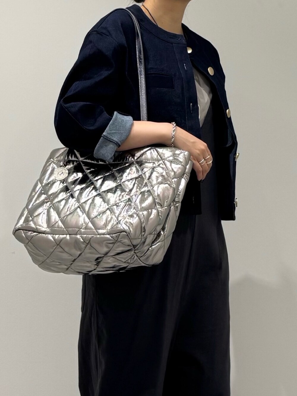 シルバー系のトートバッグ、グレー系のサロペット/オーバーオール、グレー系のTシャツ/カットソーを着用したレディースの秋コーディネートの5枚目の写真