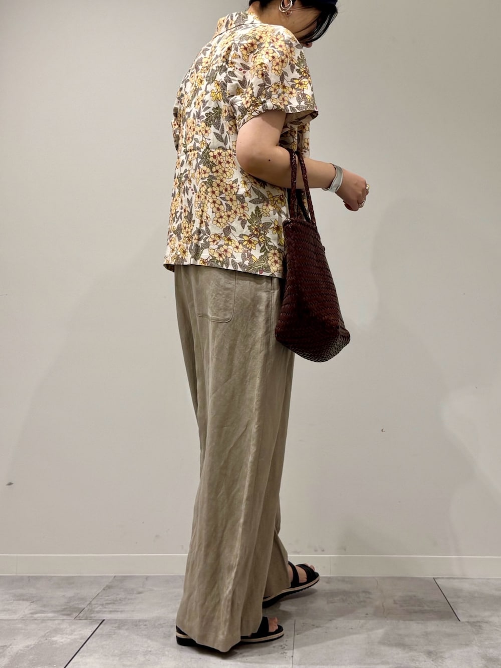 ブラウン系のトートバッグ、ベージュ系のサロペット/オーバーオール、ブラック系のサンダルを着用したレディースの春コーディネートの3枚目の写真