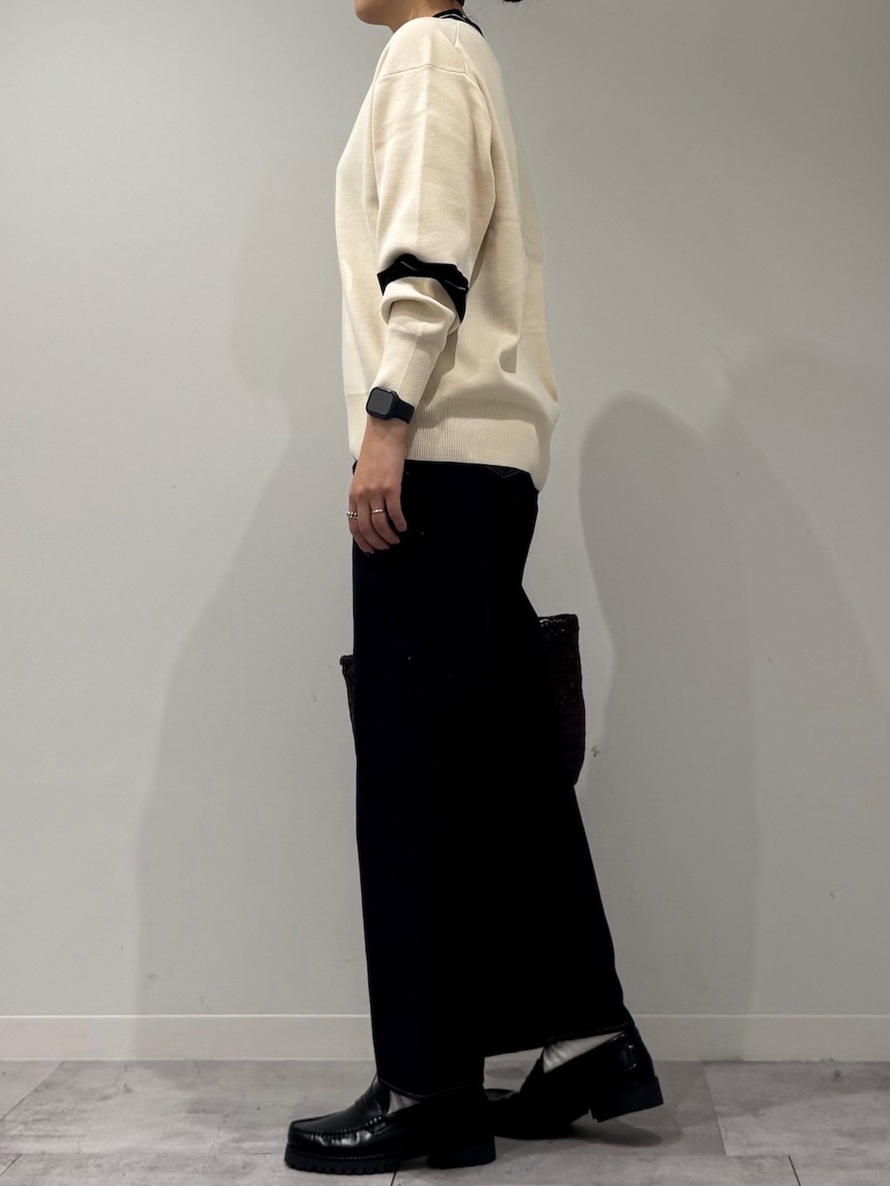 パープル系のトートバッグ、ブルー系のデニムパンツ、ブラック系のローファーを着用したレディースの冬コーディネートの5枚目の写真