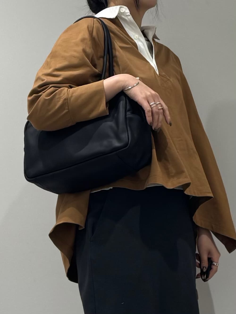 ブラック系のボストンバッグ、ベージュ系のTシャツ/カットソー、シルバー系のネックレスを着用したレディースの冬コーディネートの7枚目の写真