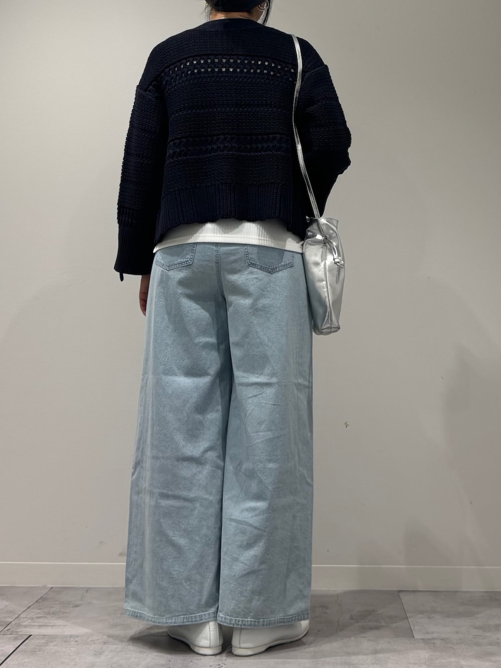 シルバー系のショルダーバッグ、ブルー系のデニムパンツ、ホワイト系のタンクトップを着用したレディースの春コーディネートの3枚目の写真