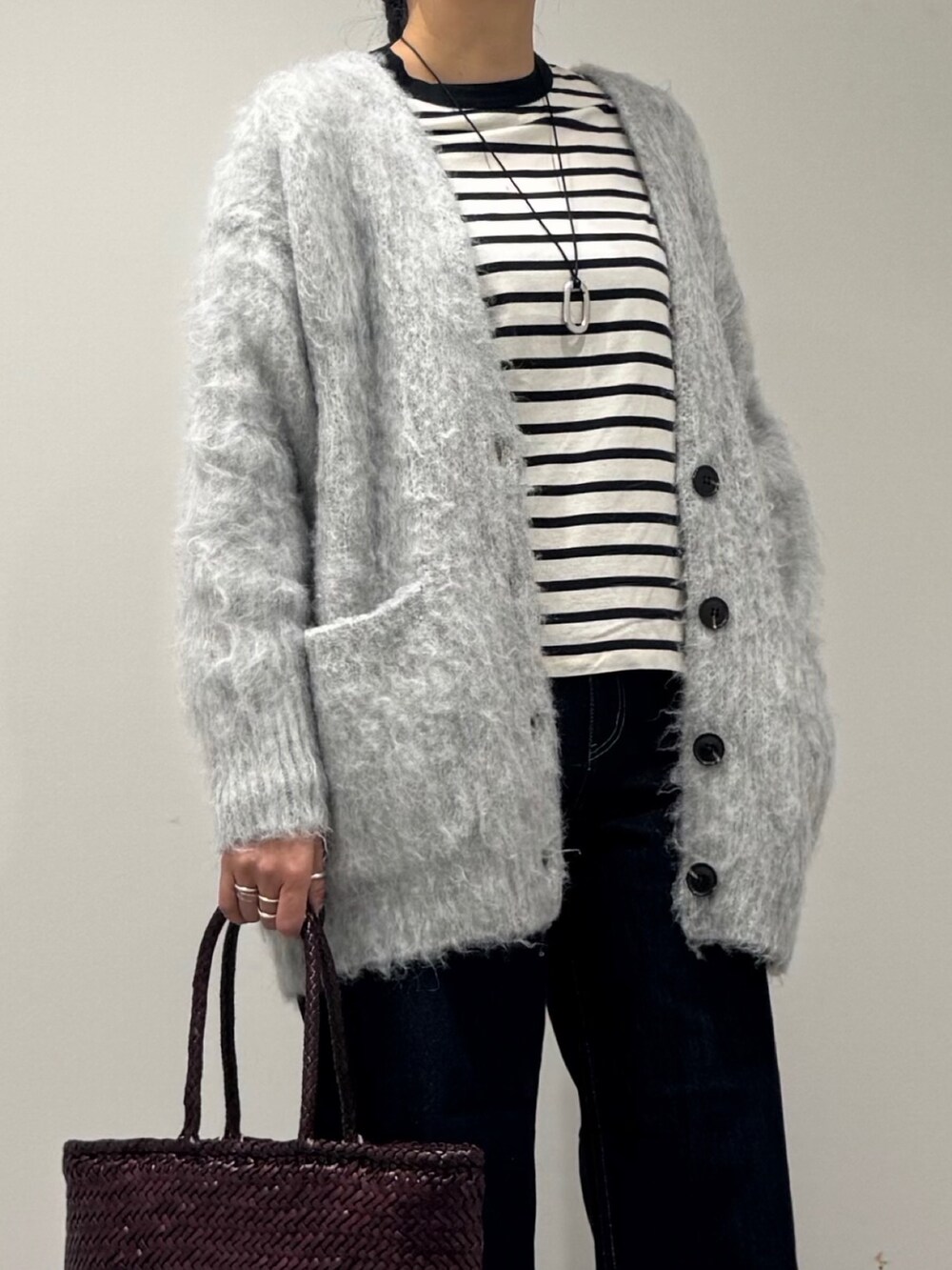 パープル系のトートバッグ、ブルー系のデニムパンツ、ブラック系のTシャツ/カットソーを着用したレディースの冬コーディネートの9枚目の写真