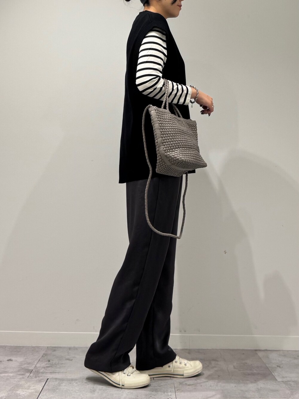 ベージュ系のトートバッグ、ブラック系のその他パンツ、ブラック系のTシャツ/カットソーを着用したレディースの秋コーディネートの2枚目の写真