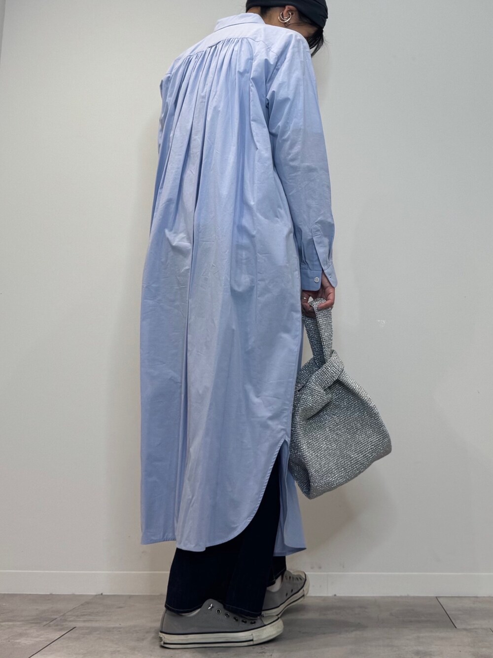 ブルー系のシャツワンピース、シルバー系のかごバッグ、ブルー系のデニムパンツを着用したレディースの春コーディネートの3枚目の写真