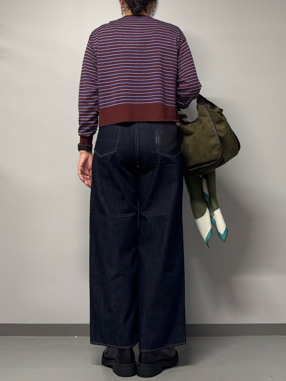ブラック系のパンプス、ブルー系のデニムパンツ、レッド系のカーディガン/ボレロを着用したレディースの秋コーディネートの4枚目の写真