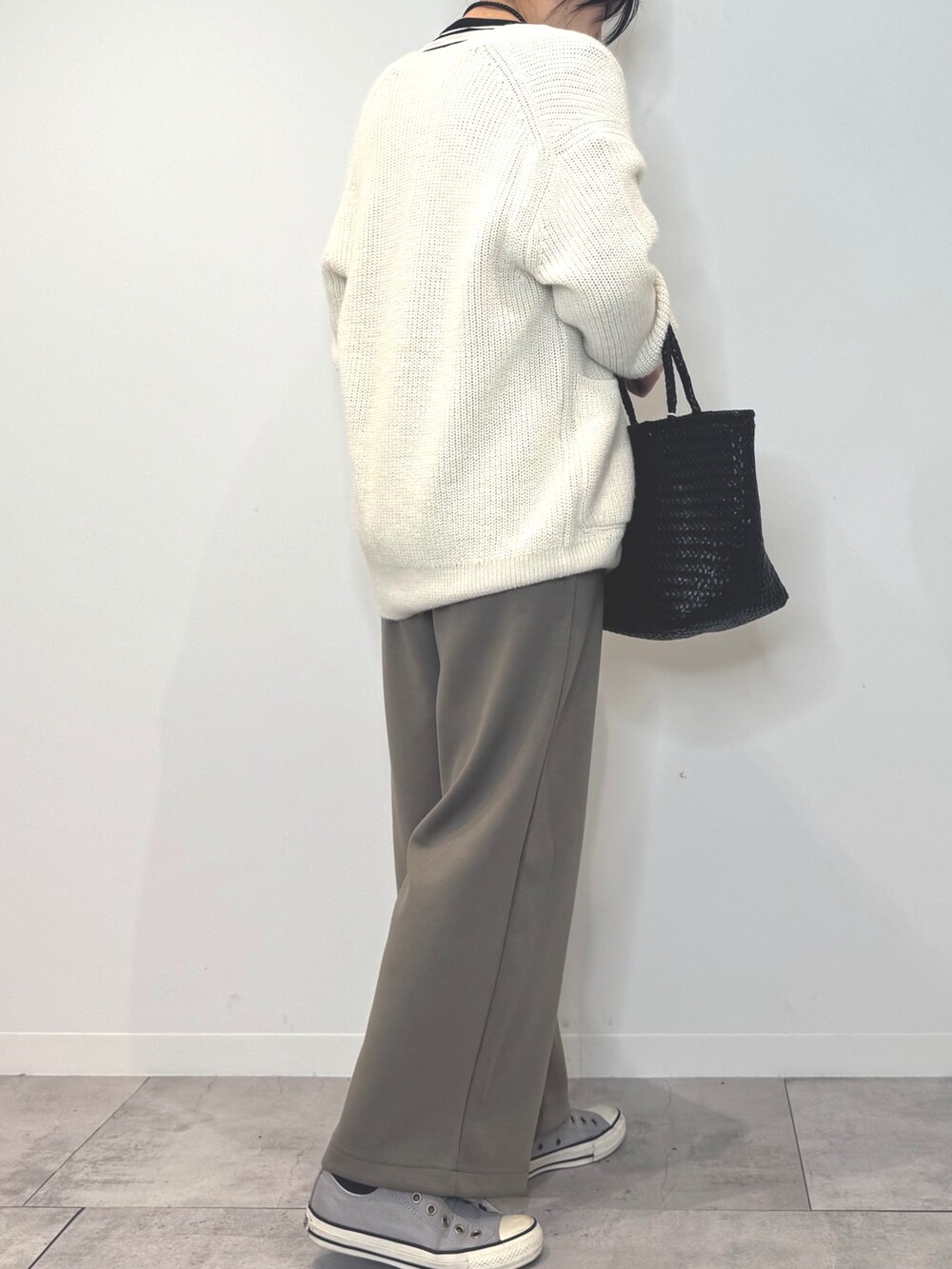 ブラック系のトートバッグ、ブラウン系のサロペット/オーバーオール、ホワイト系のカーディガン/ボレロを着用したレディースの冬コーディネートの3枚目の写真