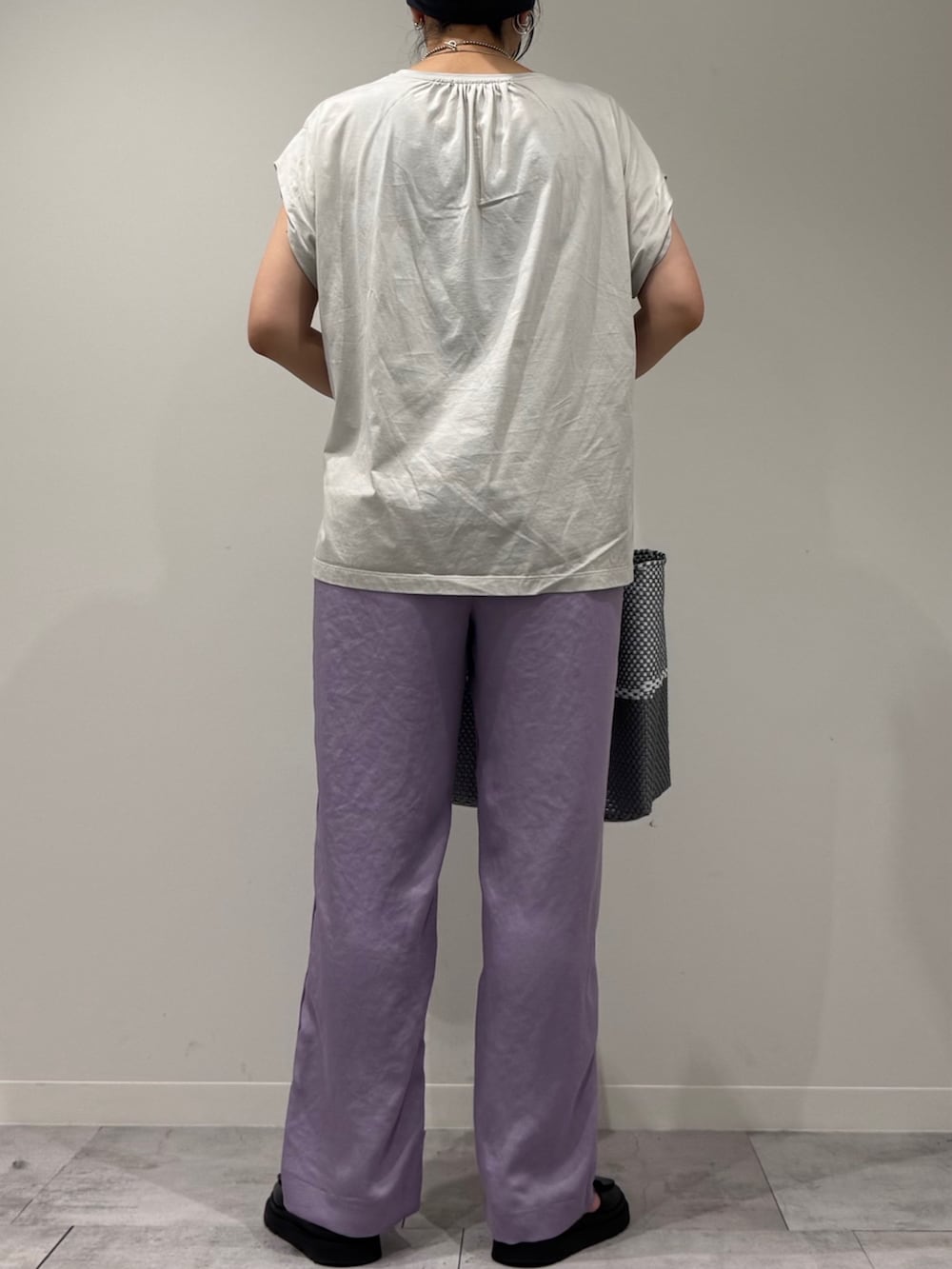 グレー系のTシャツ/カットソー、シルバー系のかごバッグ、ブラック系のサンダルを着用したレディースの夏コーディネートの3枚目の写真