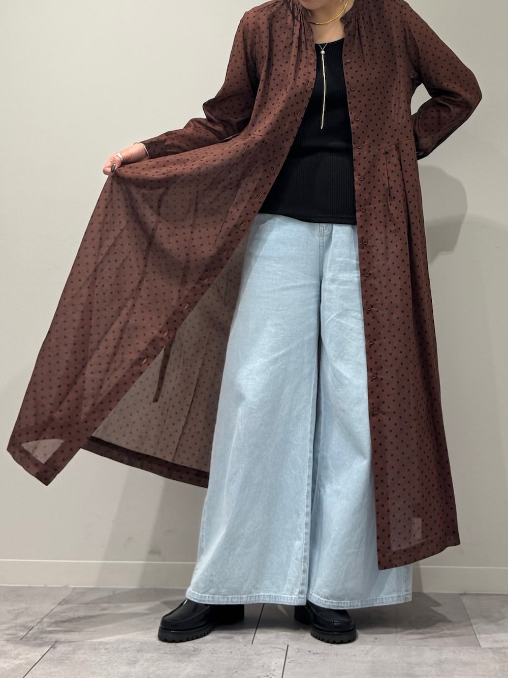 ブラウン系のワンピース、ブルー系のデニムパンツ、ブラック系のローファーを着用したレディースの春コーディネートの9枚目の写真