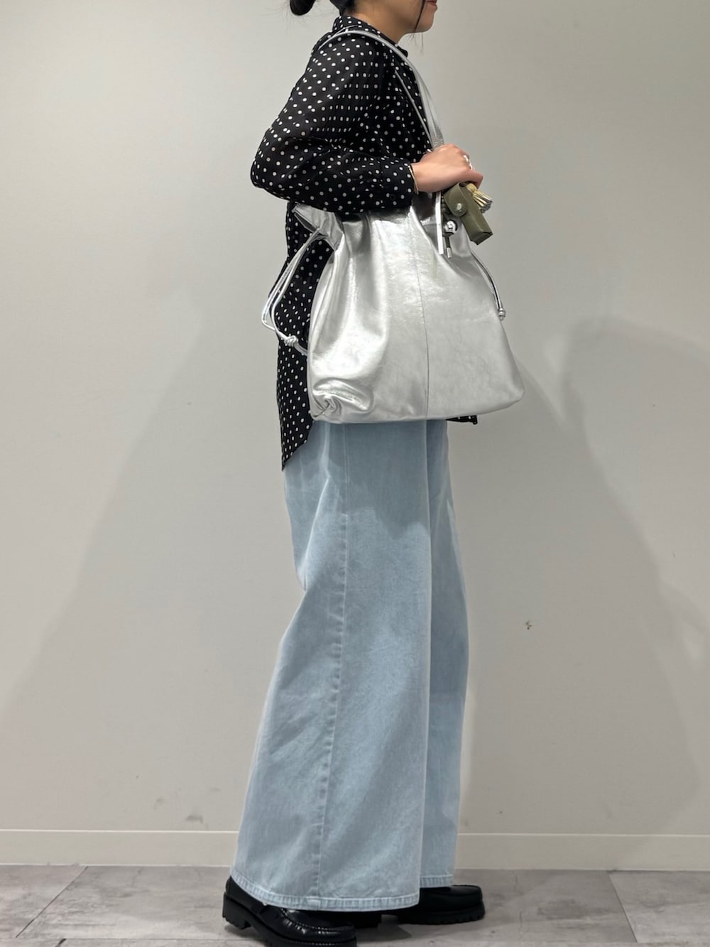 シルバー系のトートバッグ、ブラック系のローファー、ブラック系のシャツ/ブラウスを着用したレディースの春コーディネートの3枚目の写真