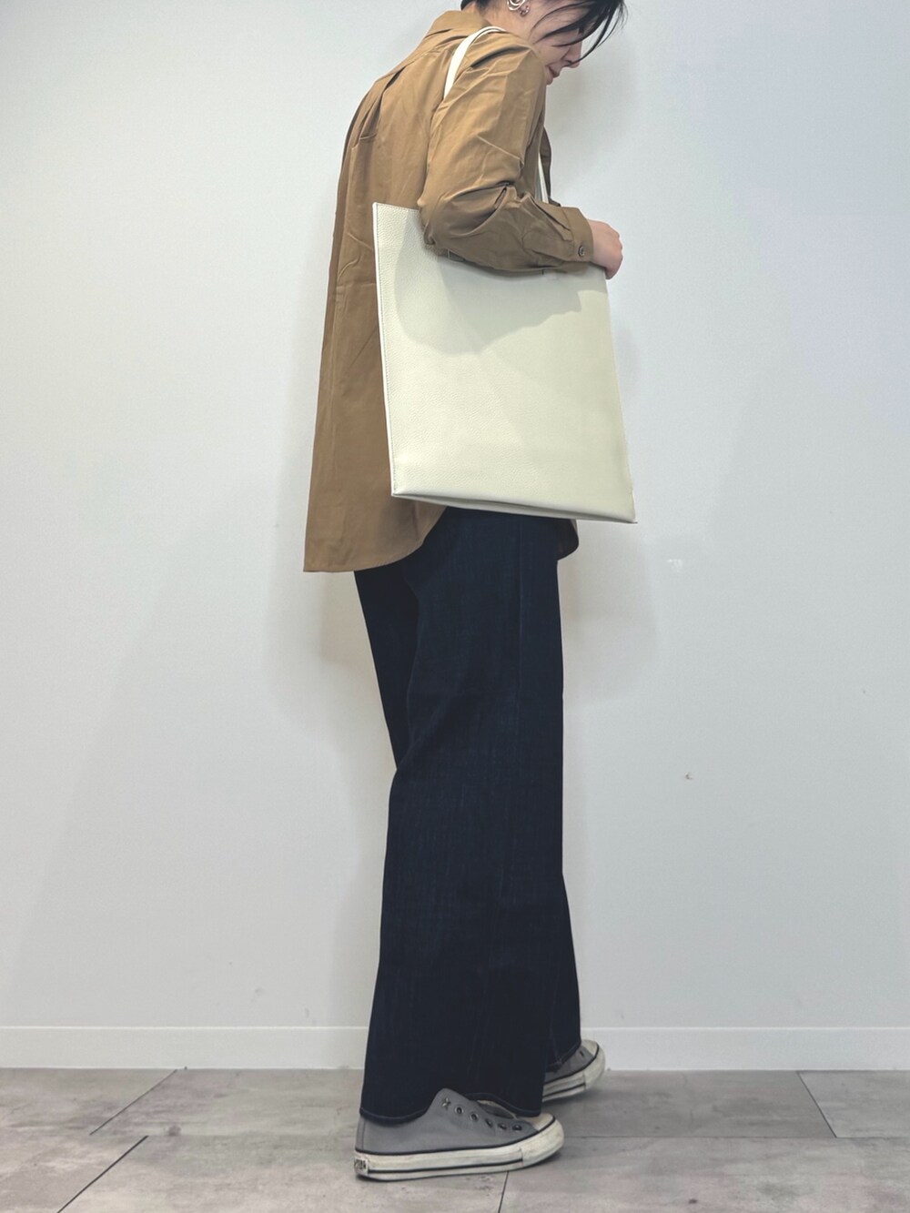 ホワイト系のトートバッグ、ブルー系のデニムパンツ、ブラウン系のシャツ/ブラウスを着用したレディースの春コーディネートの3枚目の写真