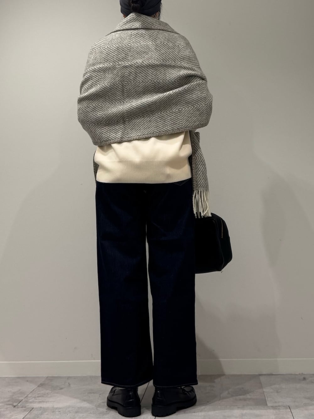 ブラック系のボストンバッグ、ブルー系のデニムパンツ、ブラック系のローファーを着用したレディースの冬コーディネートの3枚目の写真