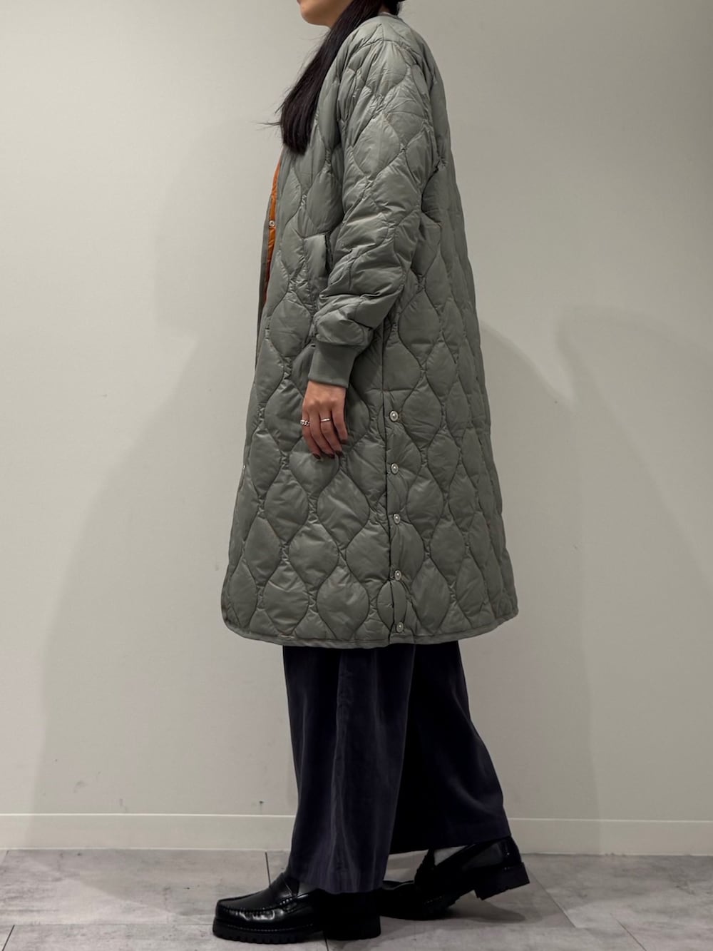 イエロー系のボストンバッグ、ブラック系のローファー、ホワイト系のベストを着用したレディースの秋コーディネートの6枚目の写真