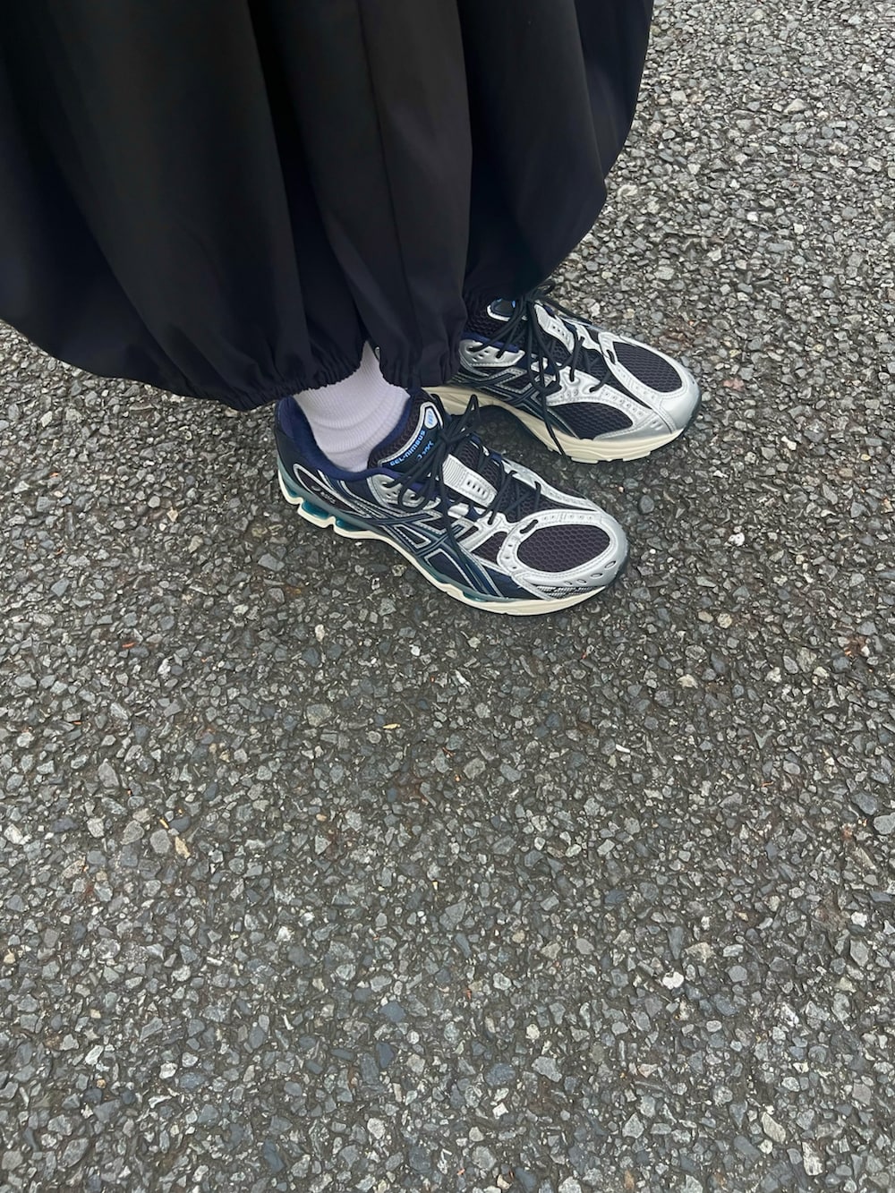 ブラック系のスニーカー、ブラック系のスカート、ブラック系のバッグを着用したレディースの秋コーディネートの4枚目の写真