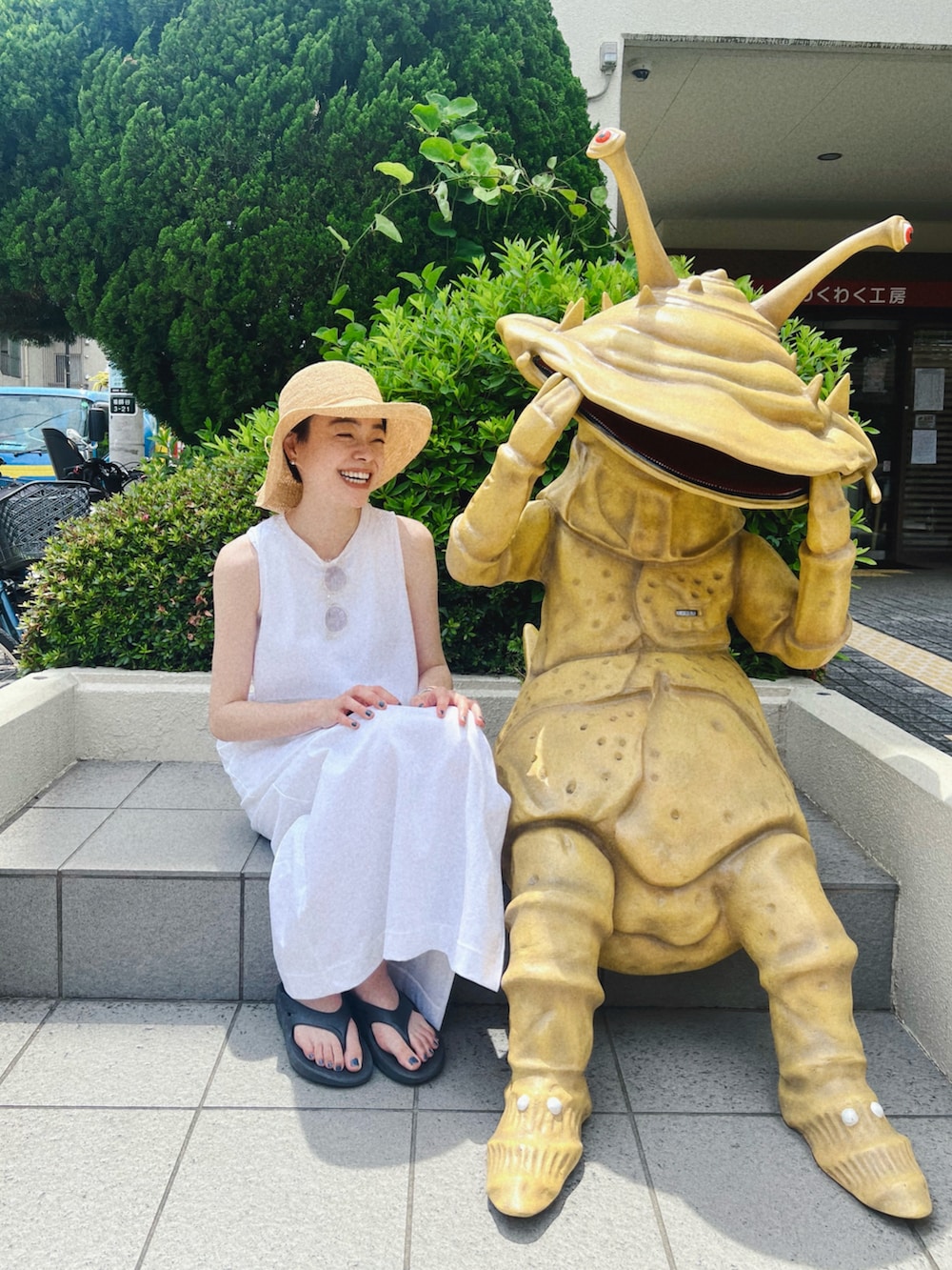 ブラック系のサンダル、ホワイト系のワンピース/ドレス、ブルー系のトートバッグを着用したレディースの夏コーディネートの3枚目の写真