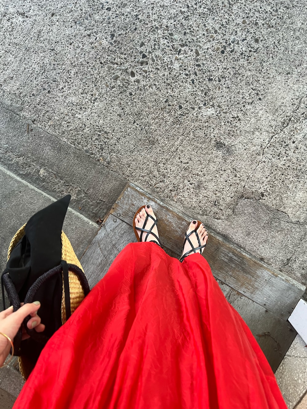 ブラック系のサンダル、ブラック系のかごバッグ、レッド系のワンピース/ドレスを着用したレディースの夏コーディネートの3枚目の写真