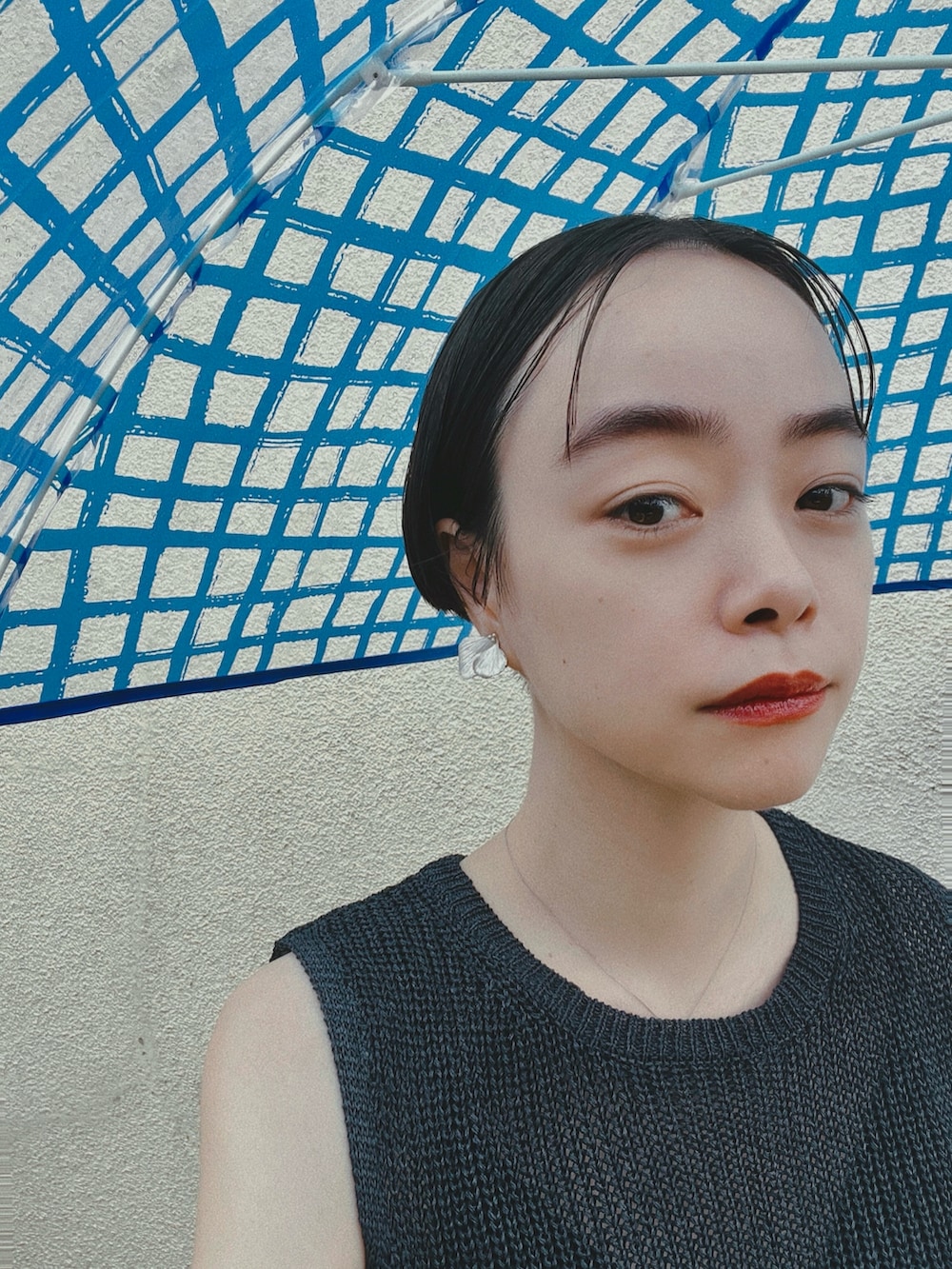 ブルー系のタンクトップ、ブルー系のデニムパンツ、ブラック系のサンダルを着用したレディースの夏コーディネートの2枚目の写真