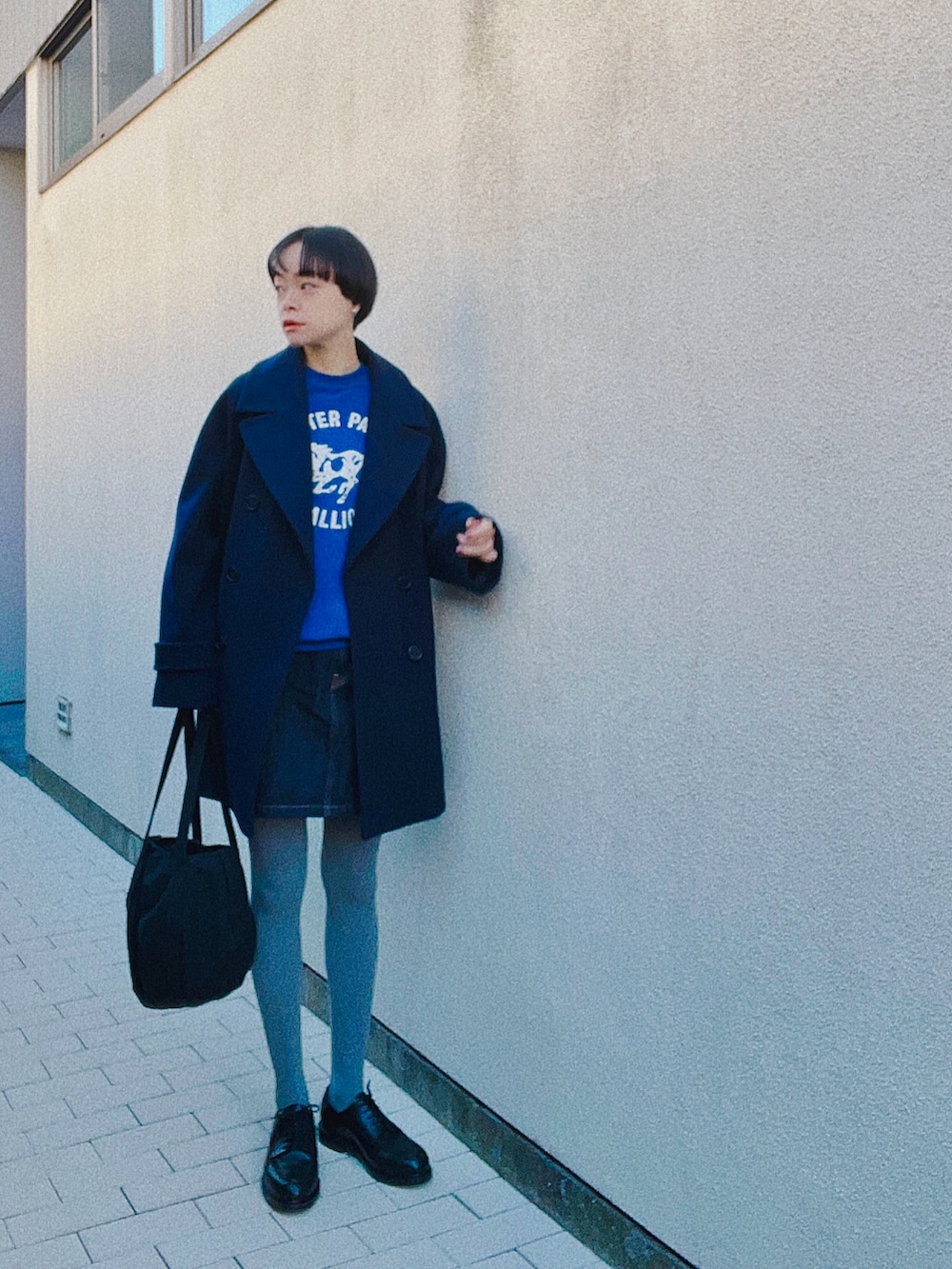 ブラック系のドレスシューズ、ブルー系のデニムスカート、ブルー系のその他アウターを着用したレディースの冬コーディネートの3枚目の写真