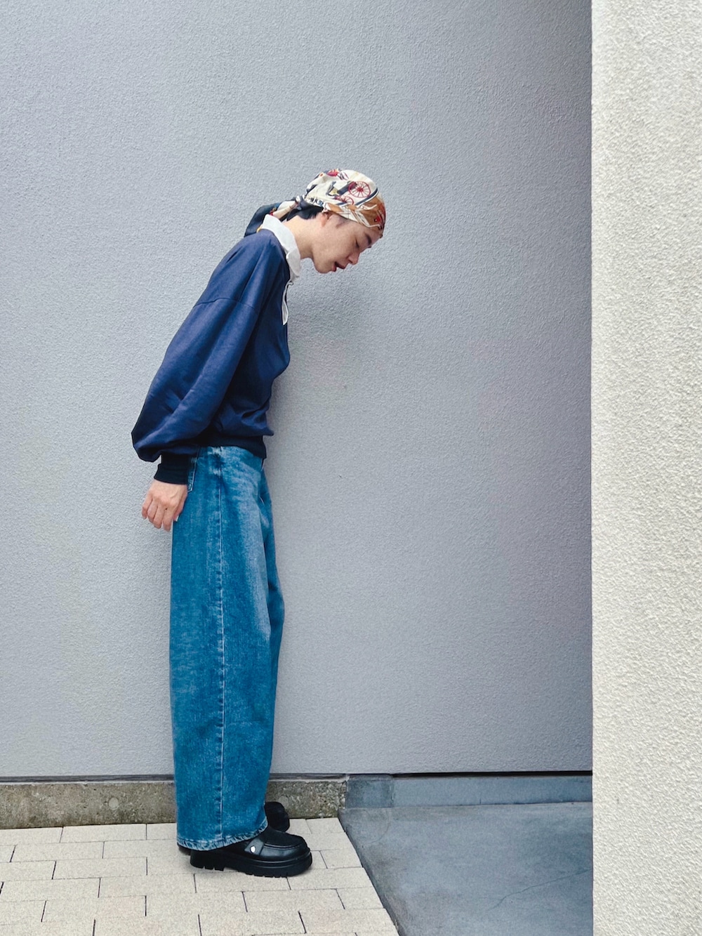 ブルー系のトップス、ブルー系のデニムパンツ、ブラック系のパンプスを着用したレディースの秋コーディネートの2枚目の写真