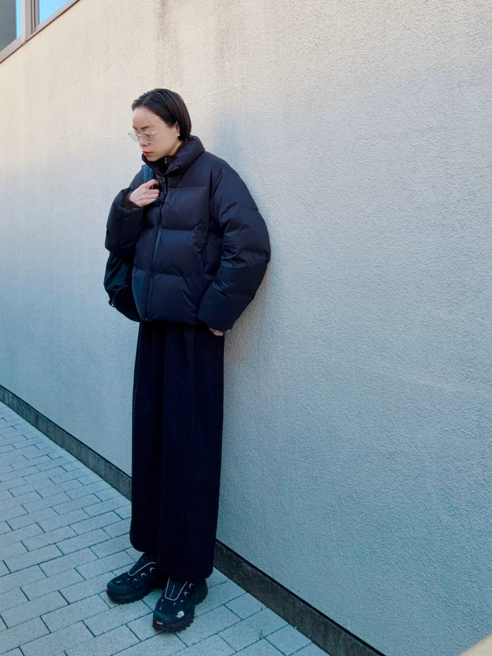 ブラック系のスカート、ブラック系のバックパック/リュック、ブラック系のシューズを着用したレディースの冬コーディネートの2枚目の写真