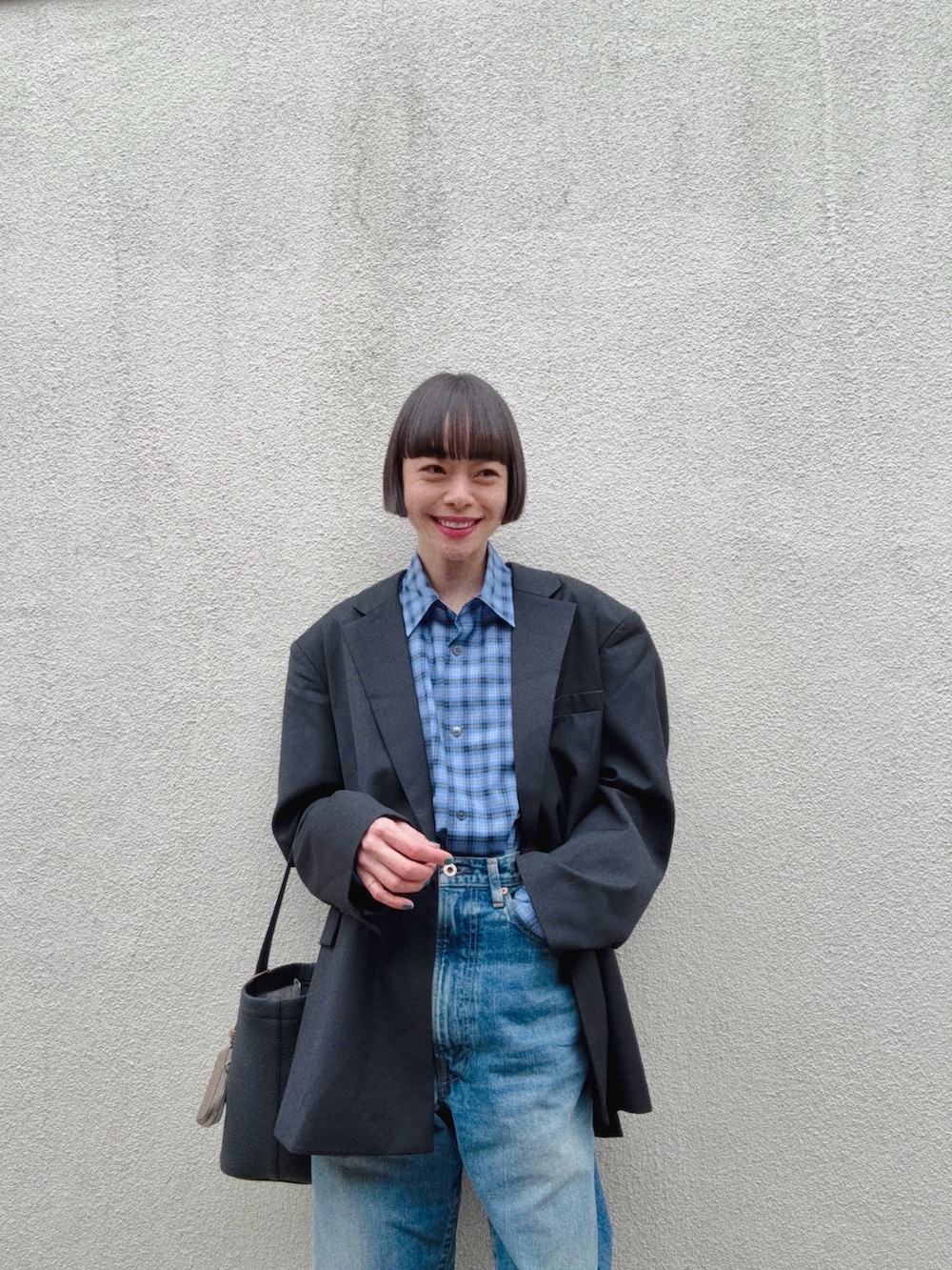 ブルー系のデニムパンツ、ブラック系のテーラードジャケット、ブルー系のシャツ/ブラウスを着用したレディースの春コーディネートの3枚目の写真