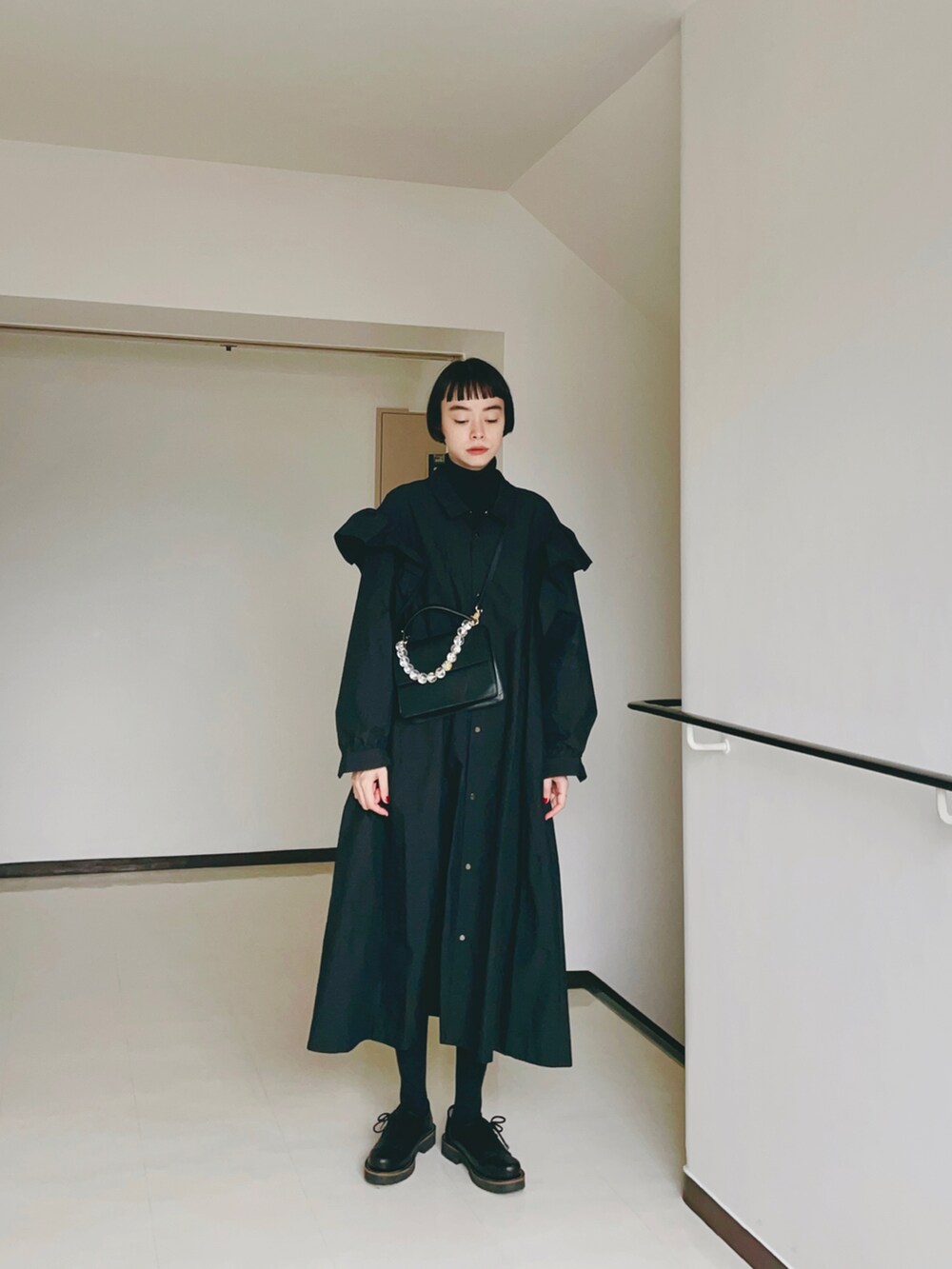 ブラック系のワンピース/ドレス、ブラック系のハンドバッグ、ブラック系のその他シューズを着用したレディースの秋コーディネートの2枚目の写真