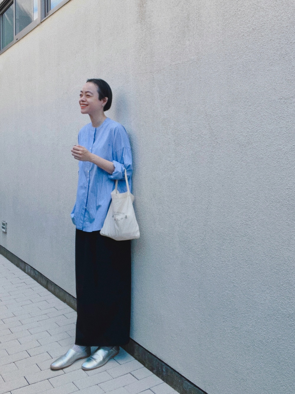 ブルー系のシャツ/ブラウス、ブラック系のスカート、シルバー系のスリッポンを着用したレディースの秋コーディネートの2枚目の写真