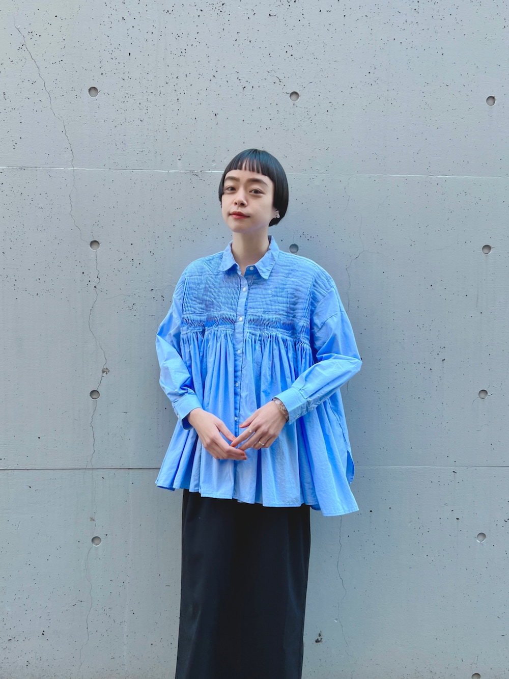 ブルー系のシャツ/ブラウス、ブラック系のスカート、シルバー系のスリッポンを着用したレディースの冬コーディネートの2枚目の写真