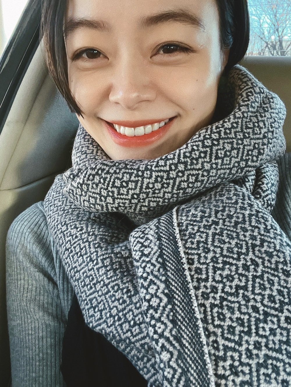 グレー系のニット/セーター、ブラック系のワンピース/ドレス、グレー系のスニーカーを着用したレディースの冬コーディネートの3枚目の写真