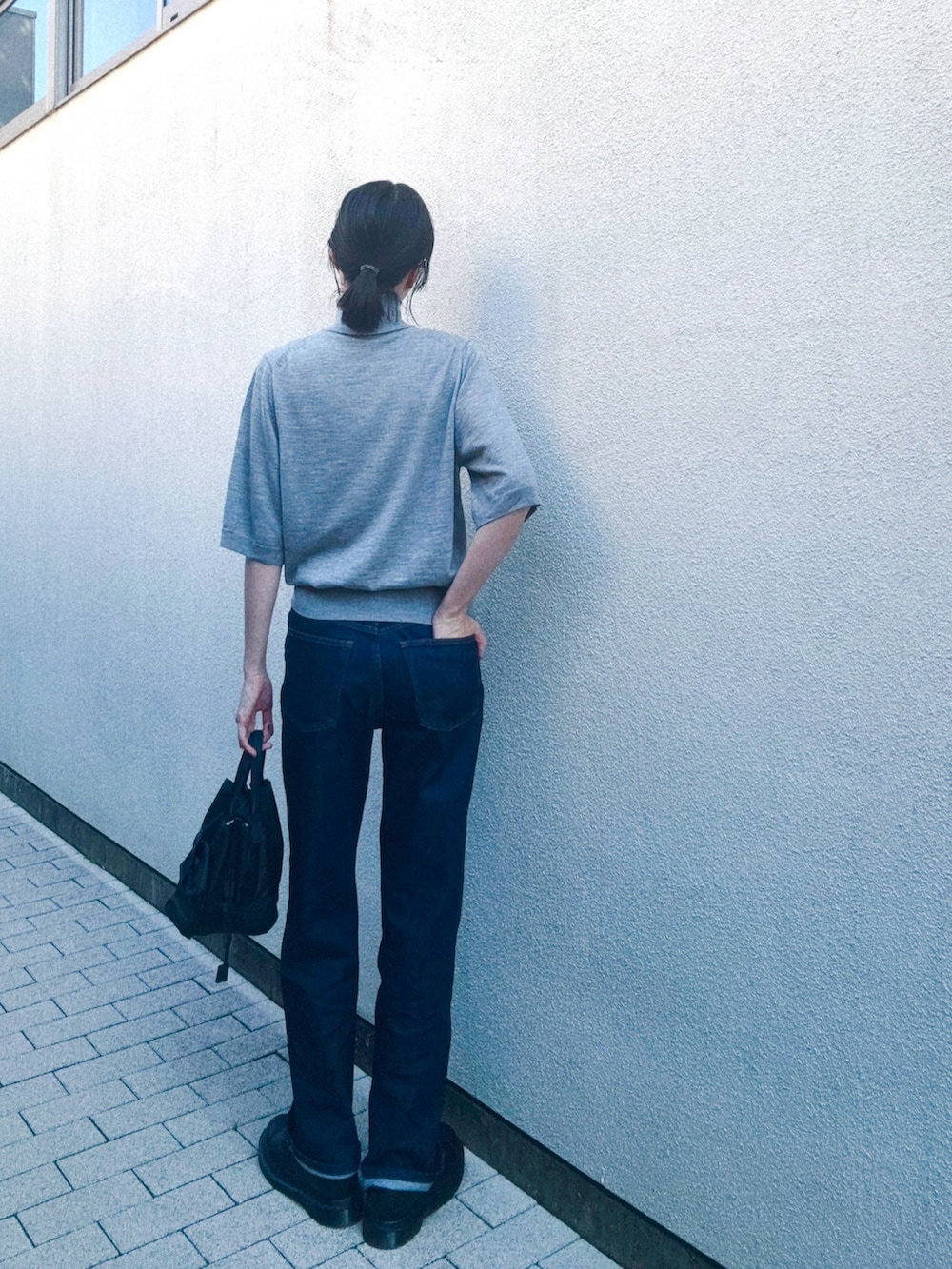 ブラック系のシューズ、ブルー系のデニムパンツ、グレー系のニット/セーターを着用したレディースの秋コーディネートの2枚目の写真
