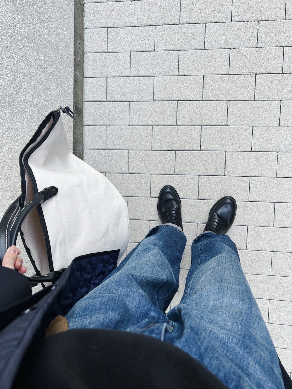 ブルー系のジャケット/アウター、ブラック系のニット/セーター、ホワイト系のバッグを着用したレディースの冬コーディネートの4枚目の写真