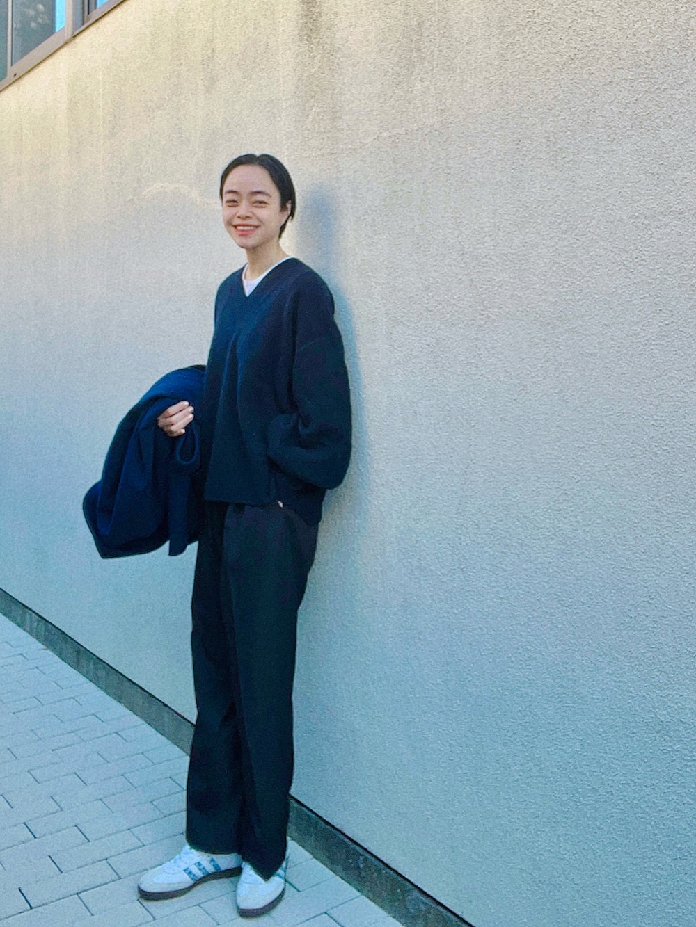 ブルー系のニット/セーター、ブラック系のスラックスを着用したレディースの冬コーディネートの2枚目の写真