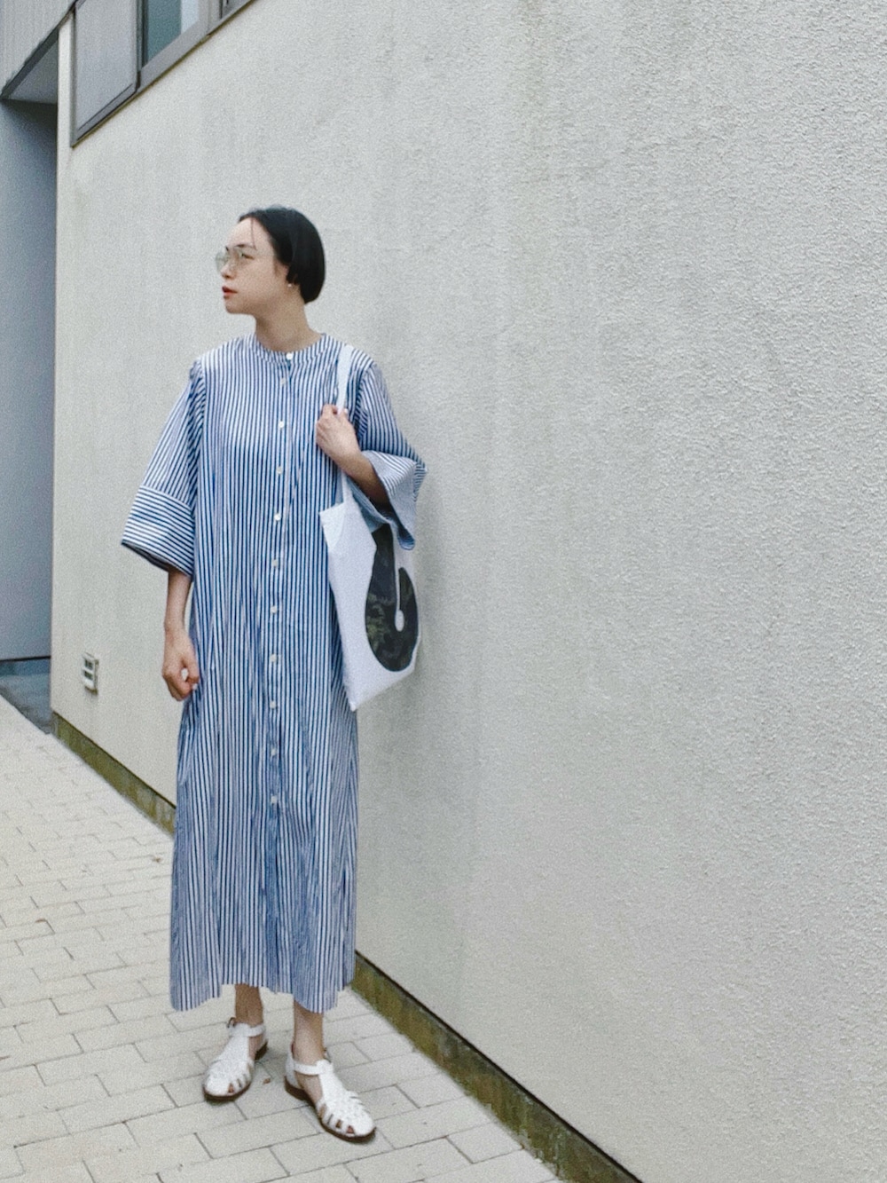 ブルー系のワンピース、ホワイト系のサンダル、その他のメガネを着用したレディースの春コーディネートの2枚目の写真