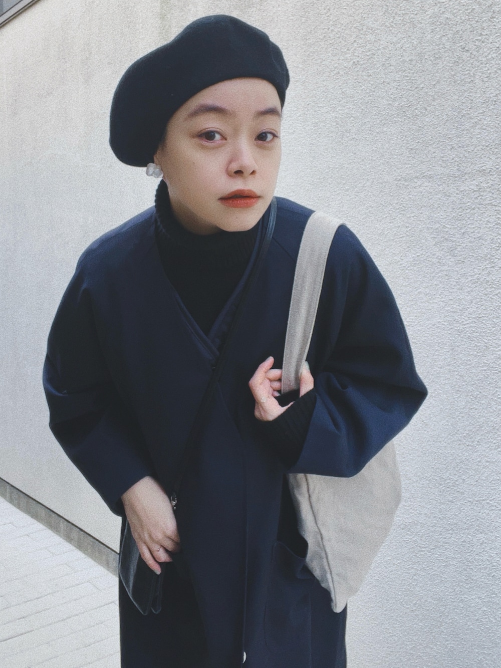 ブルー系のジャケット/アウター、ブラック系のニット/セーター、ベージュ系のバッグを着用したレディースの冬コーディネートの2枚目の写真