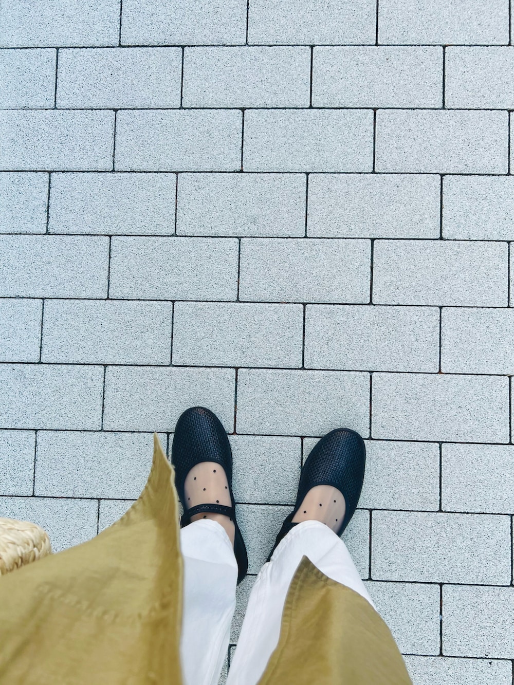 ホワイト系のデニムパンツ、ベージュ系のかごバッグ、ブラック系のシューズを着用したレディースの春コーディネートの4枚目の写真