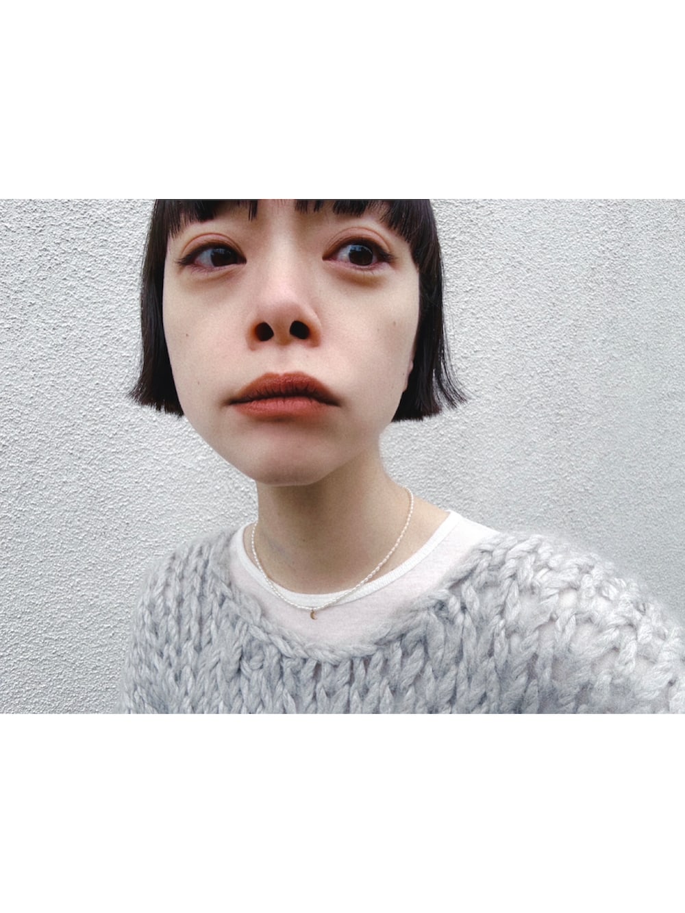 ブラック系のスウェットパンツ、グレー系のニット/セーター、ホワイト系のTシャツ/カットソーを着用したレディースの冬コーディネートの2枚目の写真