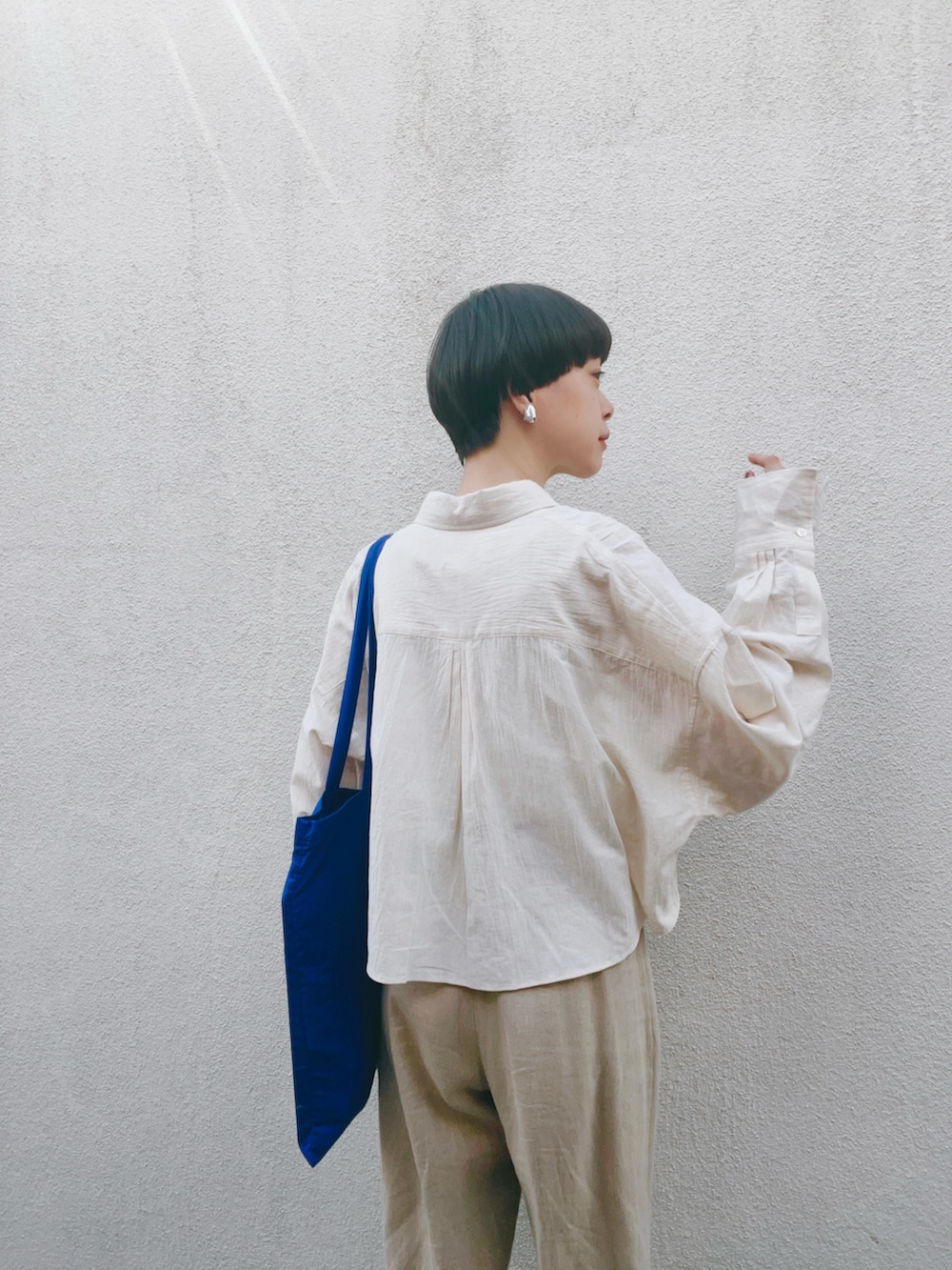 ベージュ系のシャツ/ブラウス、ベージュ系のパンツ、シルバー系のサンダルを着用したレディースの夏コーディネートの5枚目の写真