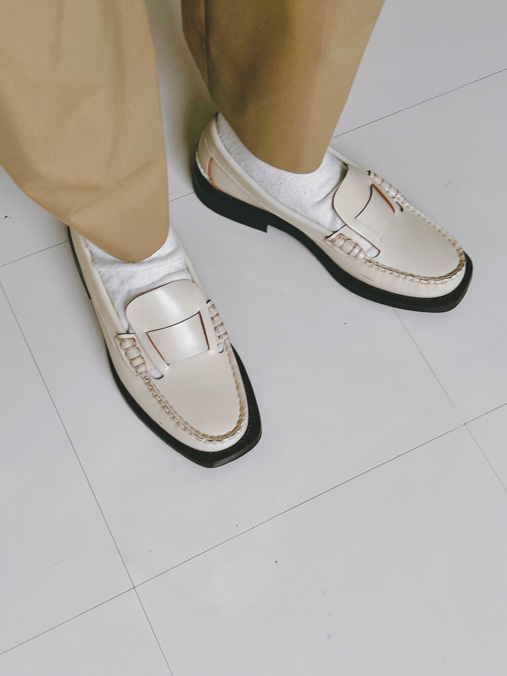 ホワイト系のシャツ/ブラウス、ベージュ系のパンツ、ベージュ系のバッグを着用したレディースの秋コーディネートの3枚目の写真