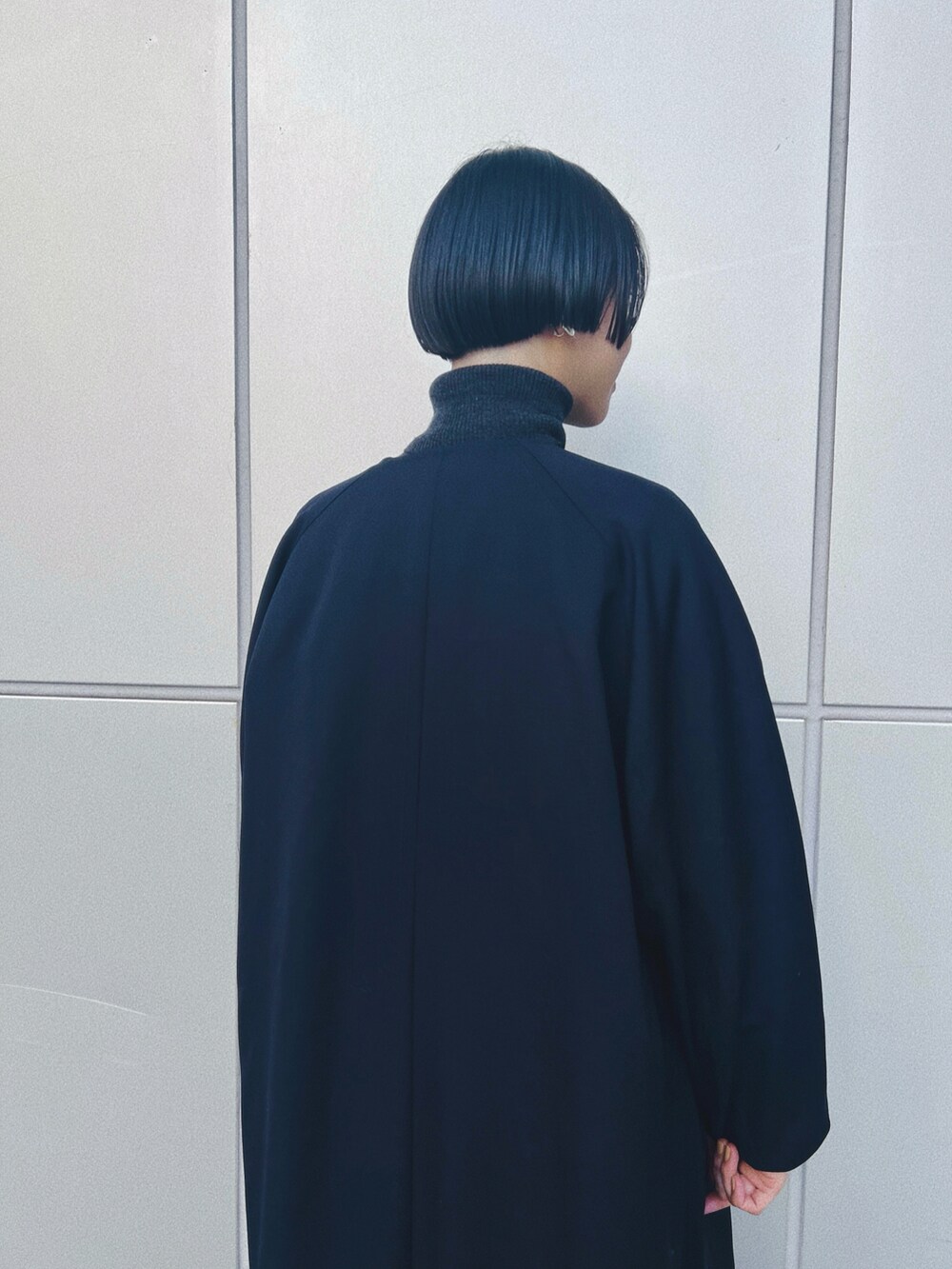 ベージュ系のバッグ、ブルー系のジャケット/アウター、ブラック系のワンピース/ドレスを着用したレディースの冬コーディネートの2枚目の写真