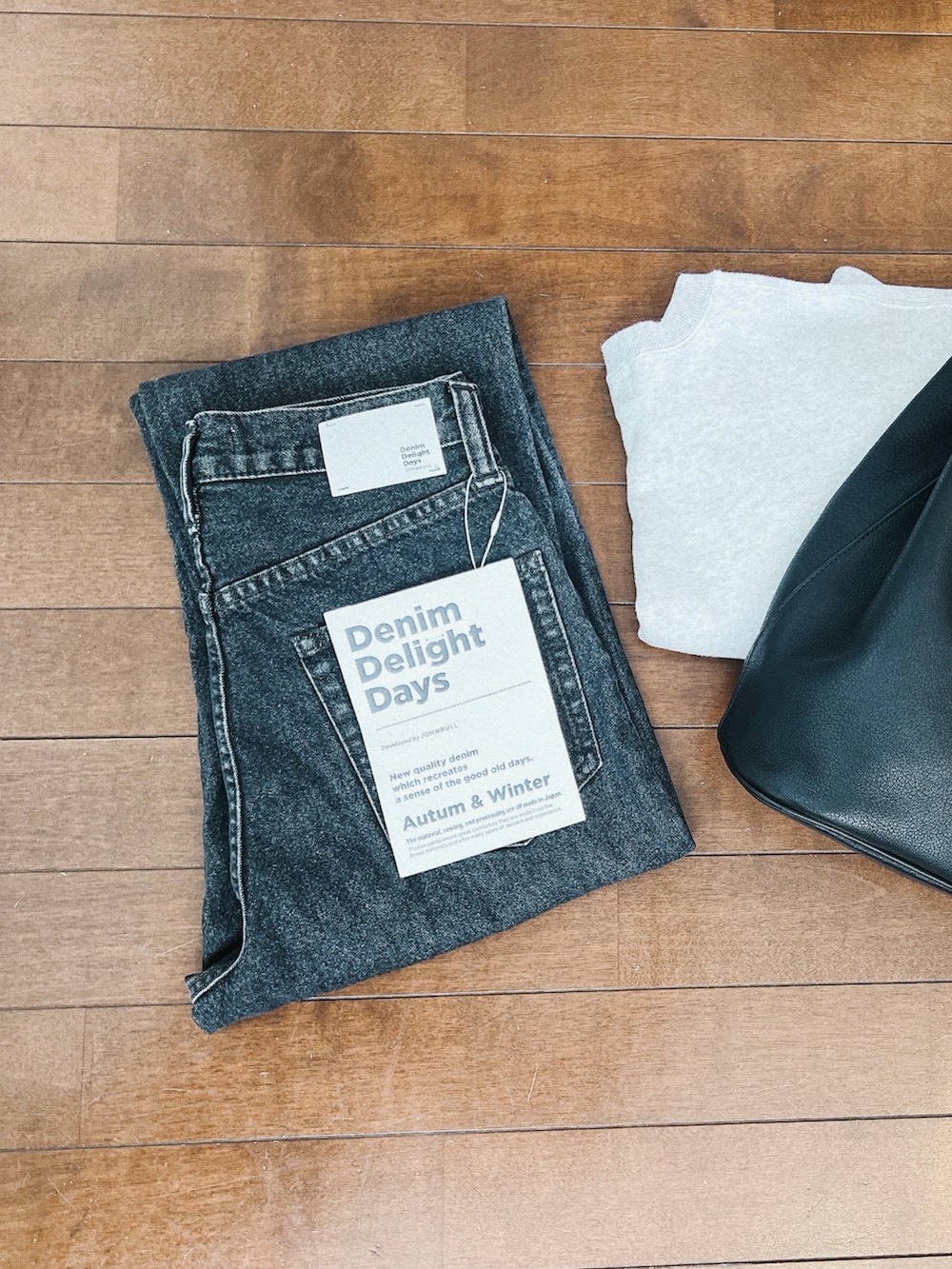 ブラック系のデニムパンツ、グレー系のスウェット、ブラック系のジャケット/アウターを着用したレディースの冬コーディネートの3枚目の写真