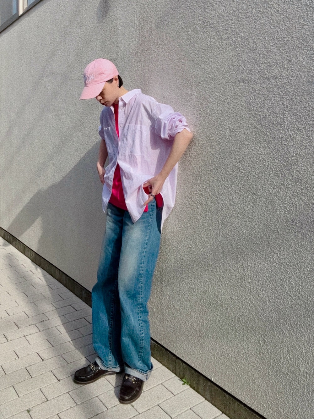 ピンク系のシャツ/ブラウス、ピンク系のニット/セーター、ブルー系のデニムパンツを着用したレディースの春コーディネートの2枚目の写真