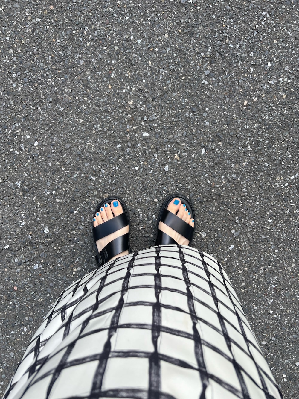 ベージュ系のスカート、ブラック系のサンダル、ホワイト系のイヤリングを着用したレディースの夏コーディネートの2枚目の写真