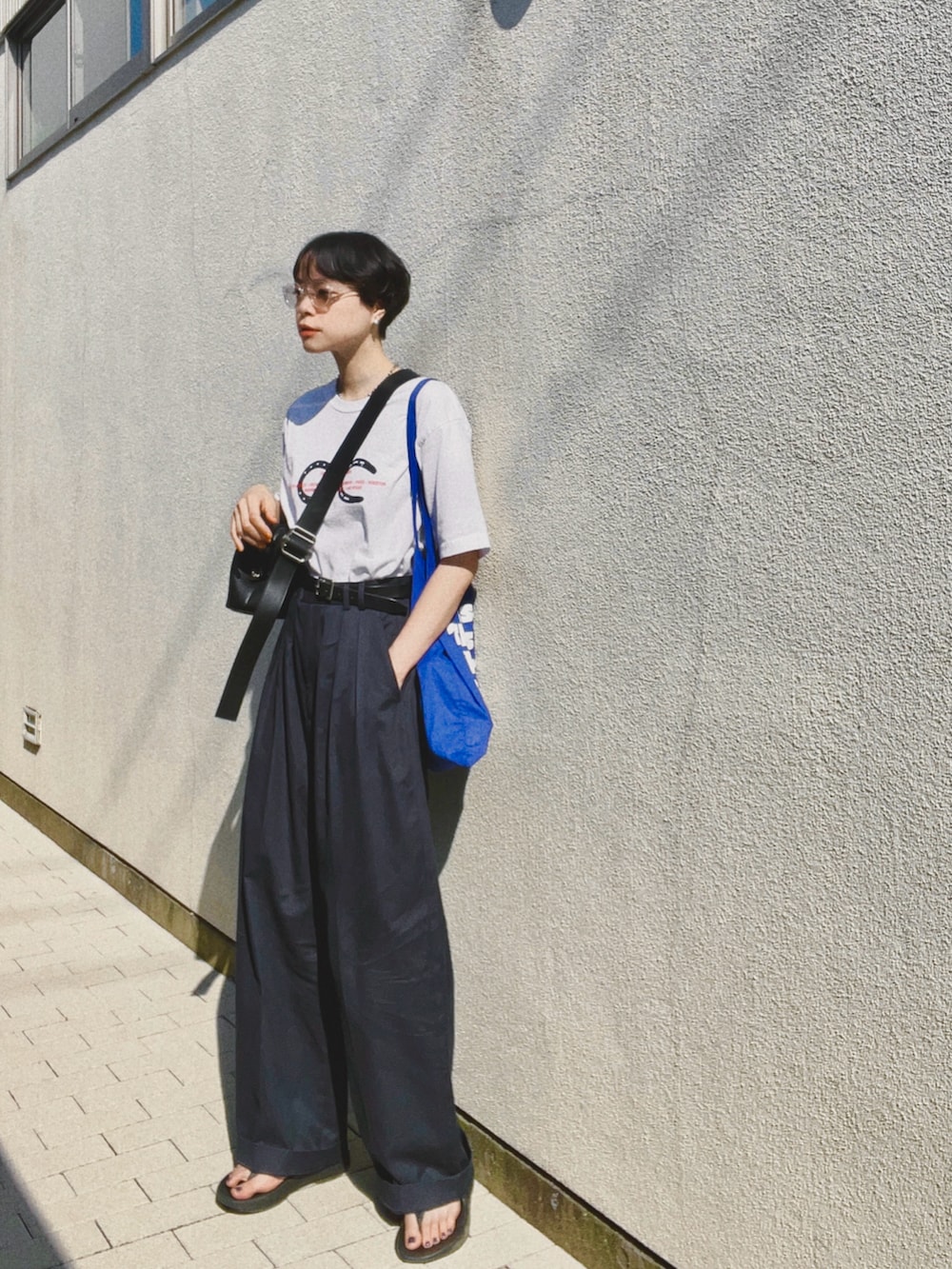 ホワイト系のTシャツ/カットソー、ブルー系のスラックス、ブルー系のトートバッグを着用したレディースの夏コーディネートの4枚目の写真