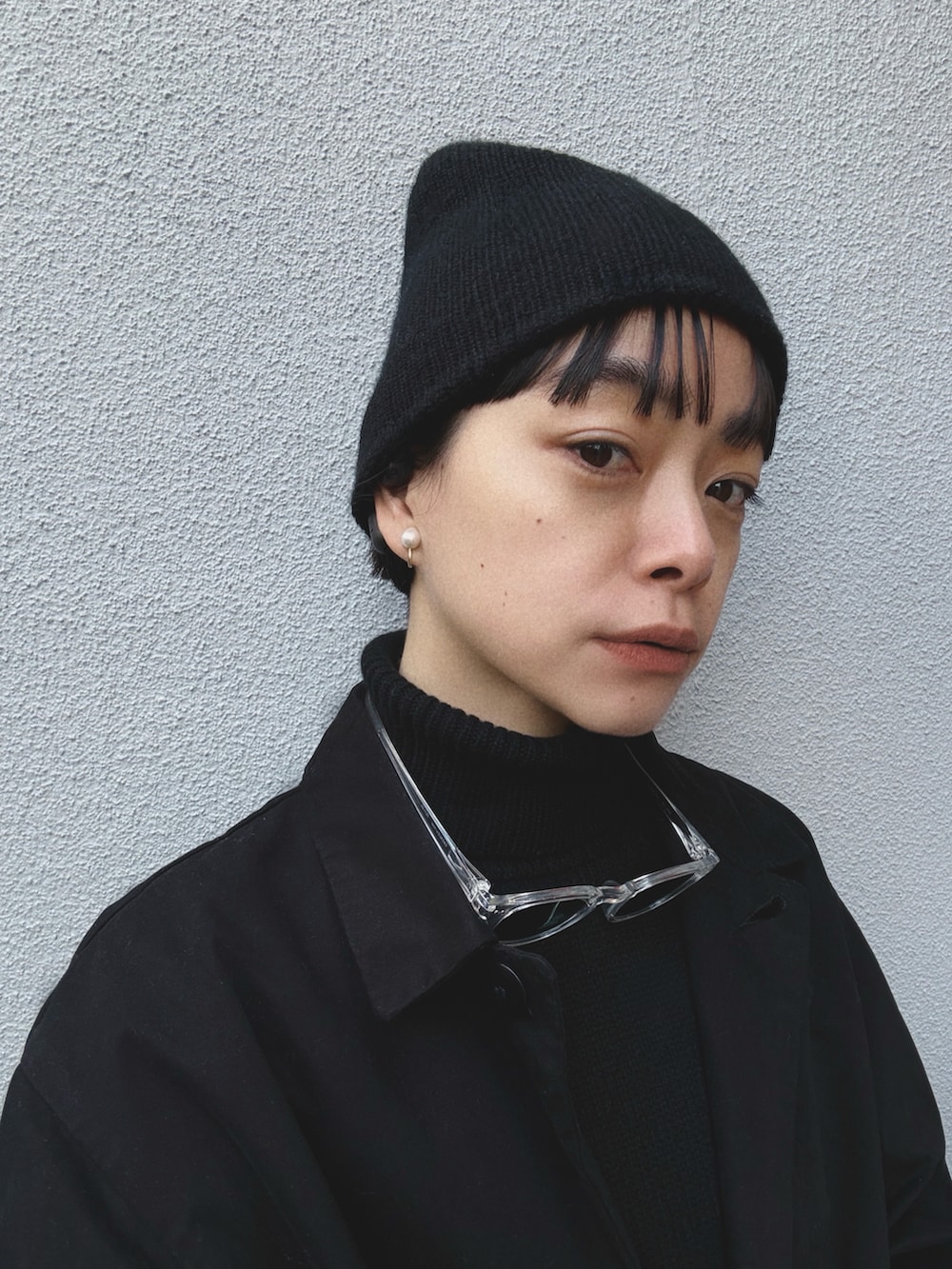 グリーン系のスラックス、グレー系のスニーカー、ブラック系のニット/セーターを着用したレディースの冬コーディネートの2枚目の写真