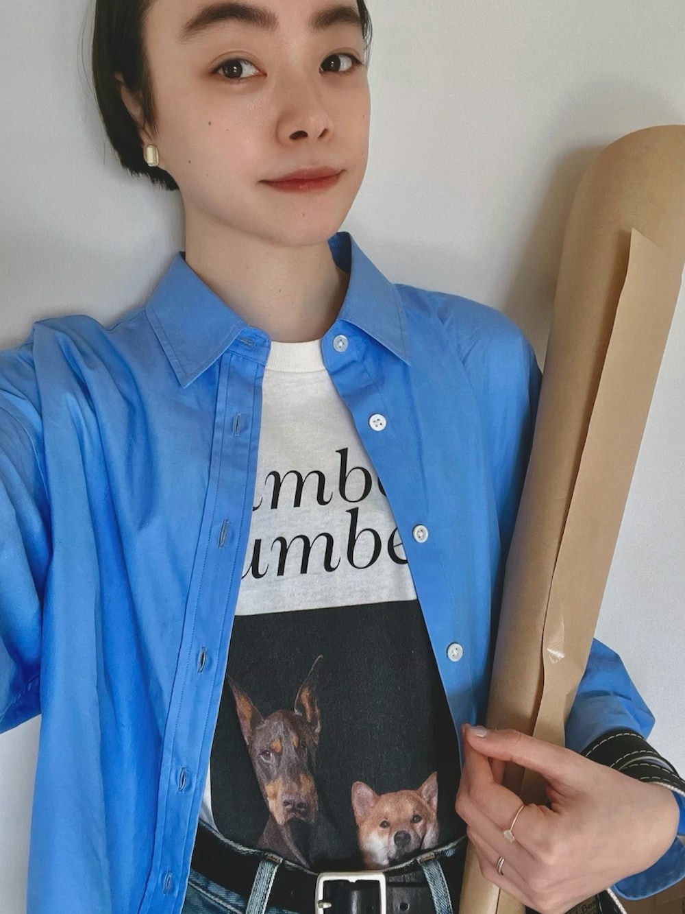 ブルー系のシャツ/ブラウス、ブラック系のトートバッグ、ブルー系のデニムパンツを着用したレディースの春コーディネートの2枚目の写真