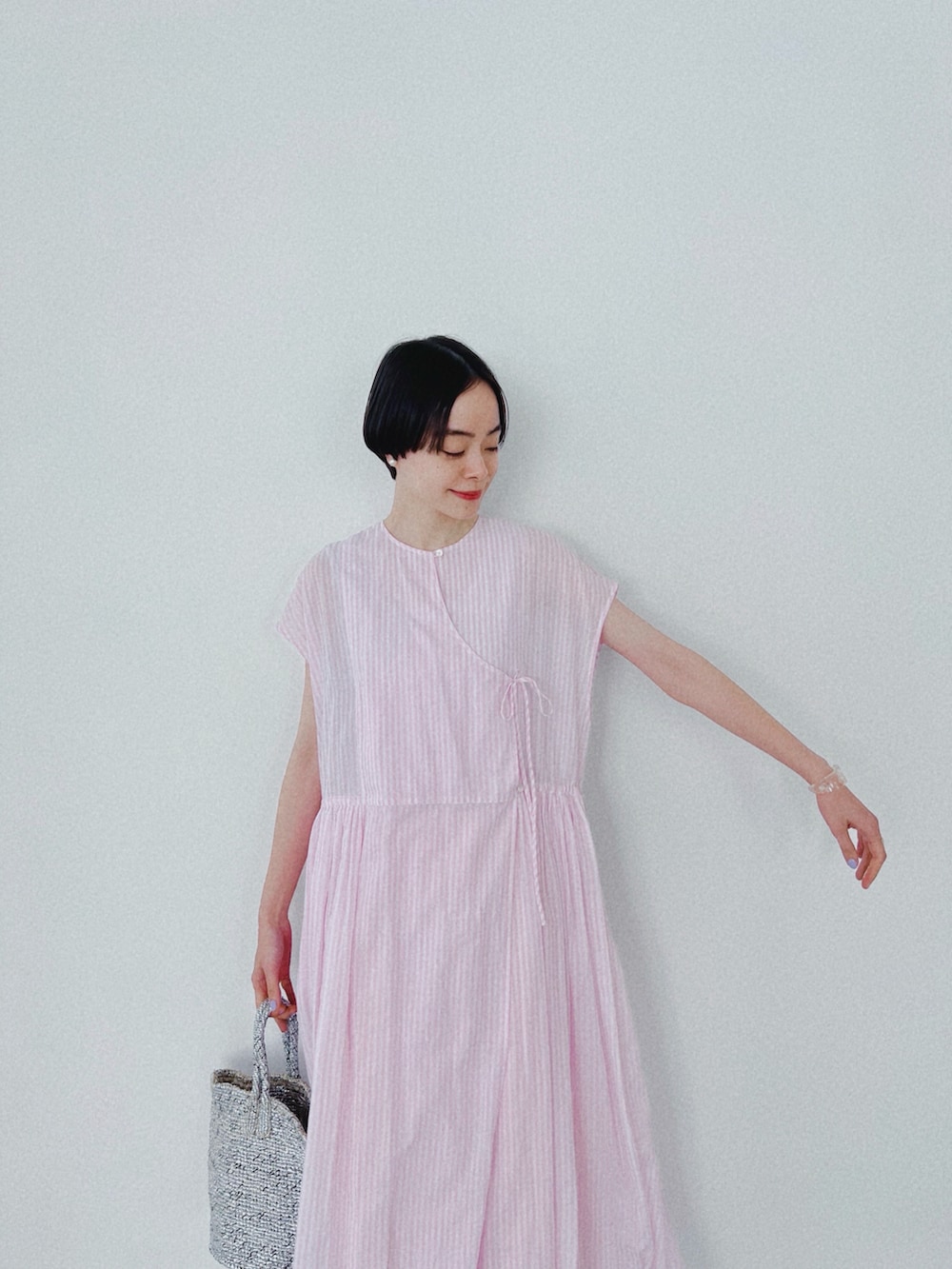 ピンク系のワンピースを着用したレディースの春コーディネートの2枚目の写真